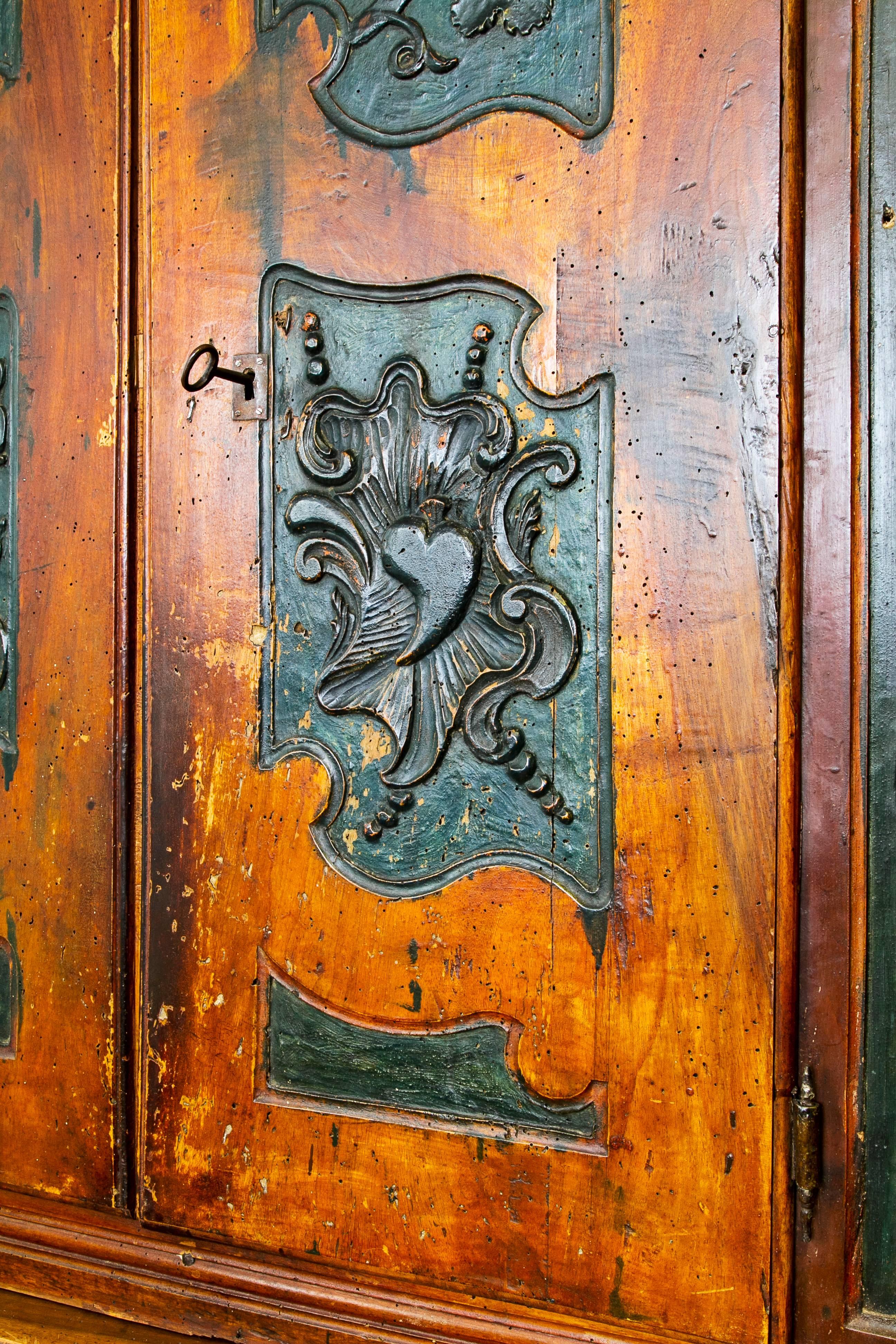 Pair of 18th century, Spanish cabinets in their original polychromy. From the region of Aragon. Both of them have the family shields carved onto the doors.
 