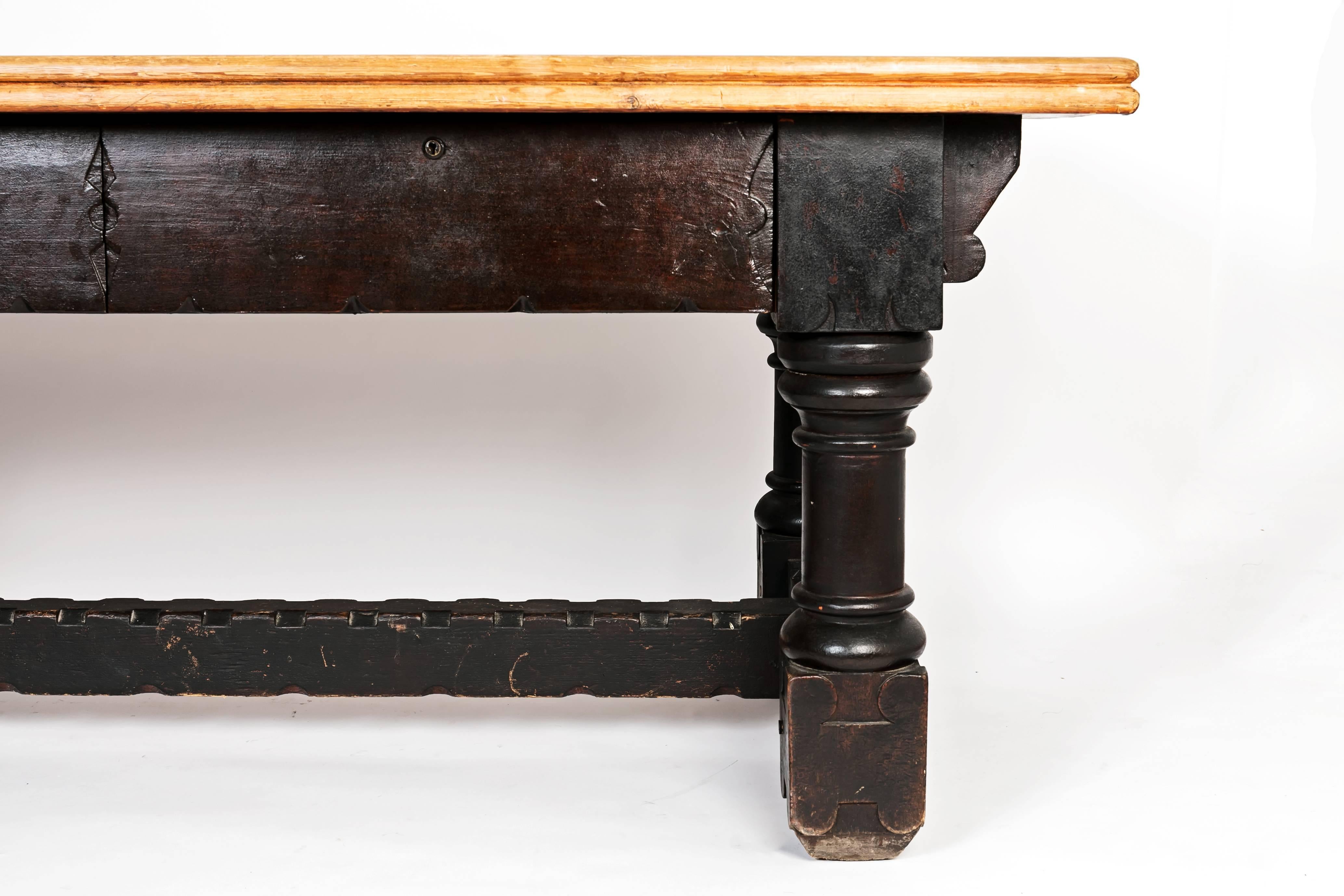 19th century English country wooden table in black with plain wood top. Has two drawers.
 