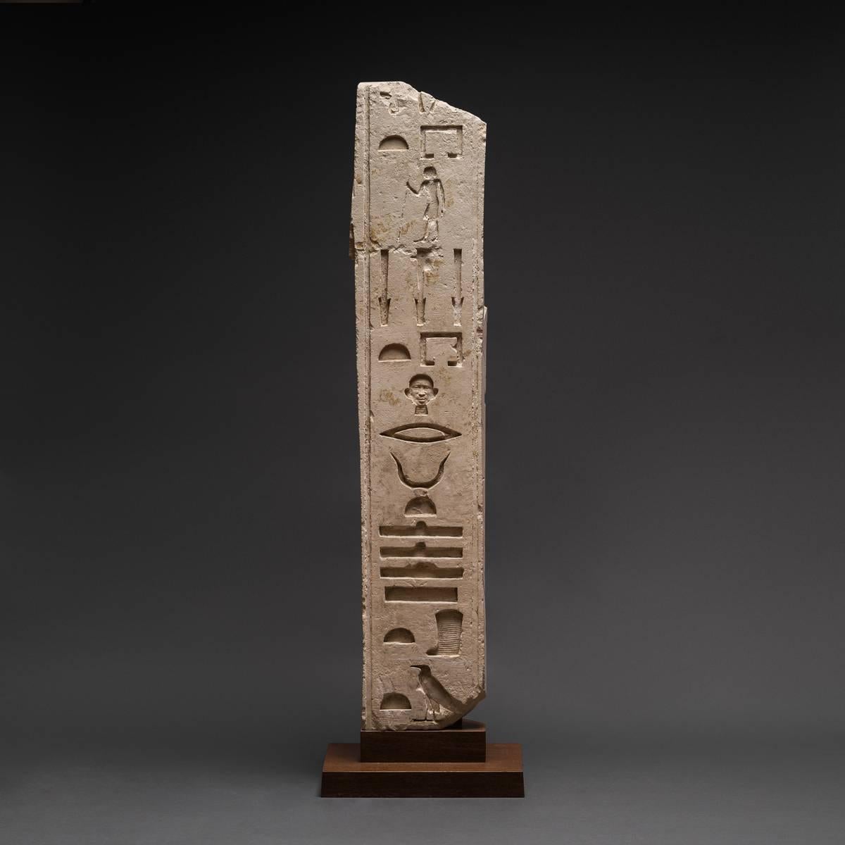 Sculpted in classically-designed sunken hieroglyphs, this single column of inscription, oriented to the left, contains a partial string of titles belonging to the cursus honorum of a highly placed official in pharaoh’s court. The inscription as