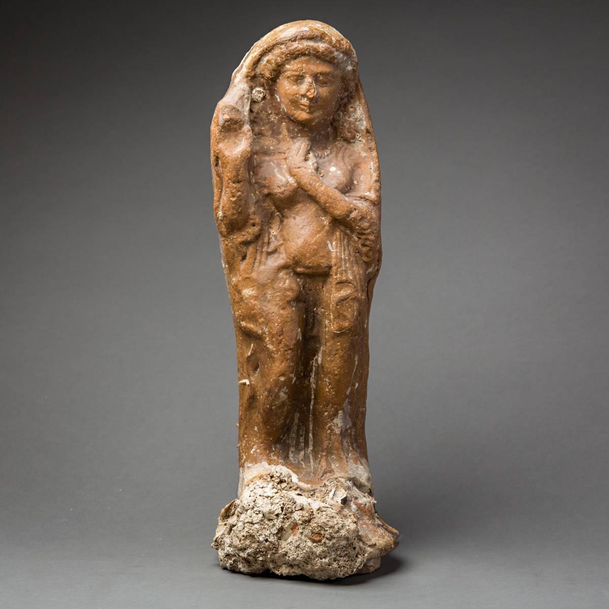 This outstandingly beautiful and well-preserved ceramic sculpture is a votive figure from the middle of the first millennium BC, and represents a Phoenician deity. It depicts a goddess standing on an integral base, which bears an offerings bowl