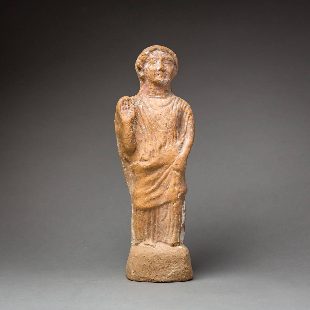 This well-composed ceramic sculpture is a votive figure from the middle of the first millennium BC, and represents a Phoenician deity. The goddess is standing on an integral base (partially restored) and is unusually well-and extensively detailed.