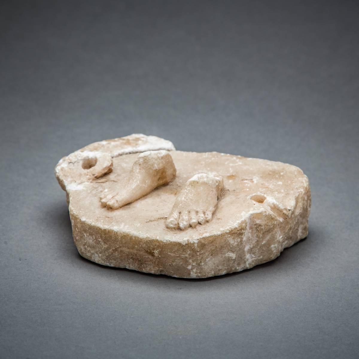 This is a truly delightful and somewhat quirky object of the remains of a small male marble sculpture. Although only his extremities survive, the piece is still aesthetically pleasing and entertaining. The feet appear natural, even the toenails have