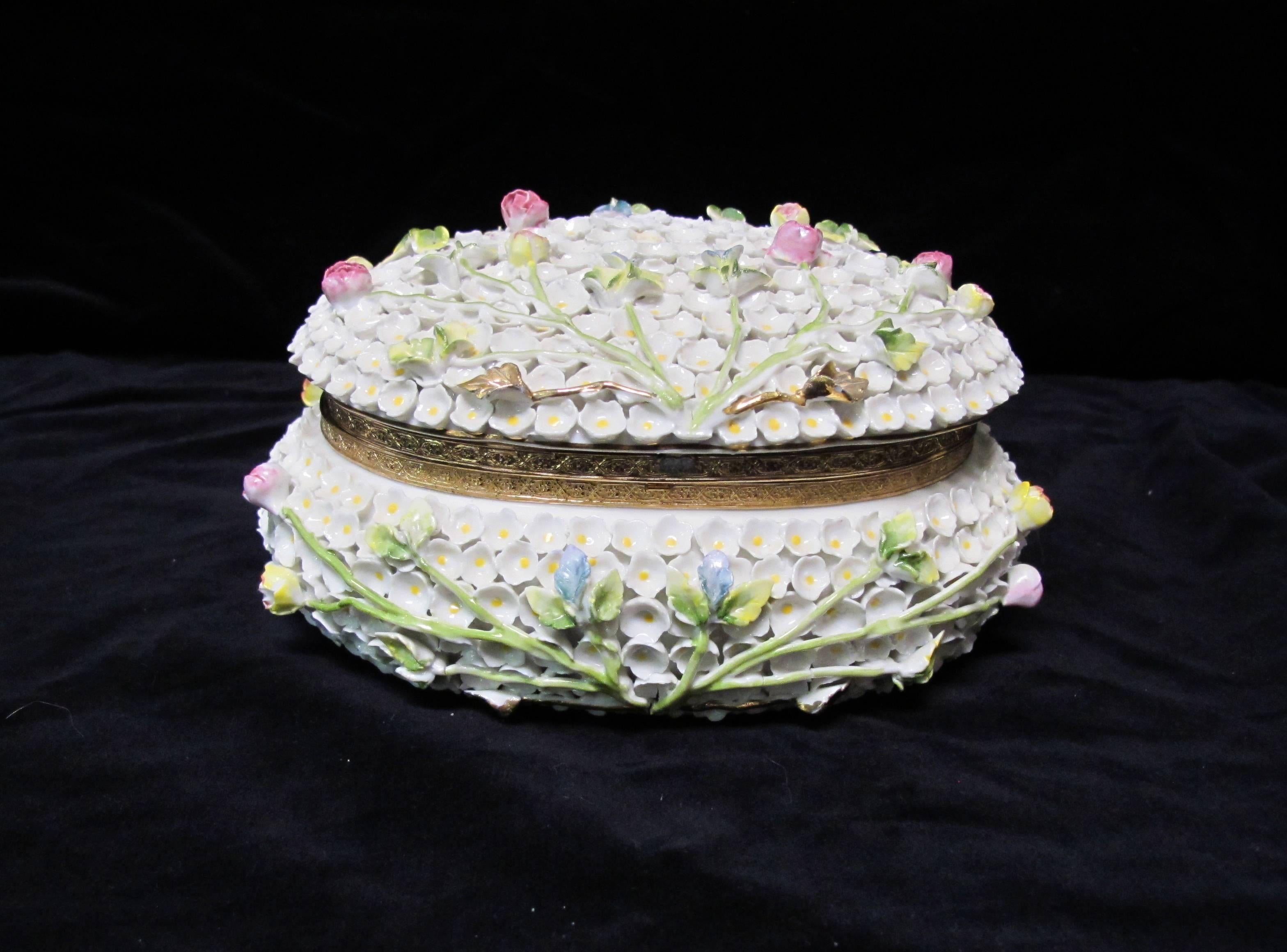 This antique Dresden porcelain box is covered in hand-built flowers and adorned with gold leafing, and hinged. It measures 8 x 6