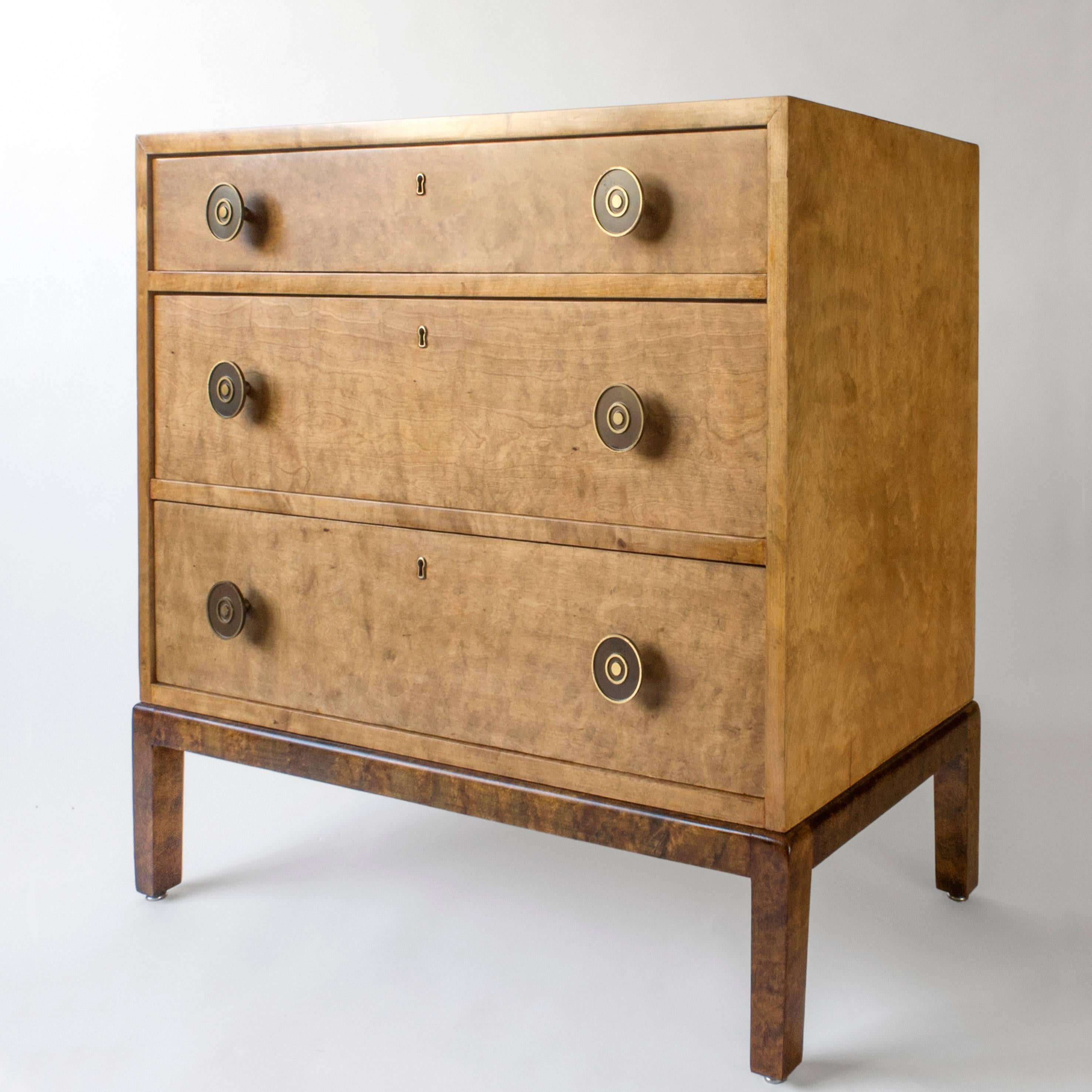 Professionally restored, in great condition, and ready to add to your collection. 

The rectangular top above three stacked drawers, each drawer centering a brass keyhole flanked by circular gilt and patinated brass pulls, terminating on an