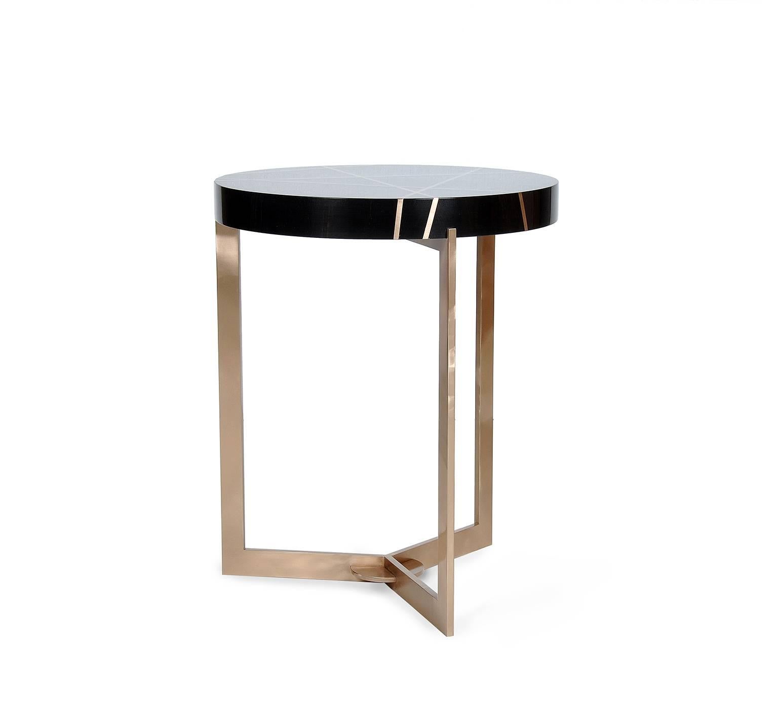 The ray end table in ebony and bronze is created to be a notable accent piece. It is at once rich, luxurious and complicated, while maintaining a serious and serene form.   Ebony is a member of the diosypros family and comes from northern Africa. It