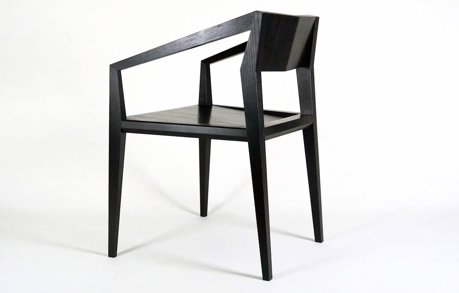 Geometric chair constructed solely out of solid wood featuring faceted legs and arms and a scooped seat. Arms feature exposed spline detail and chamfered edges. 

This chair was designed with experimental joinery combining a Maloof joint and Mortise