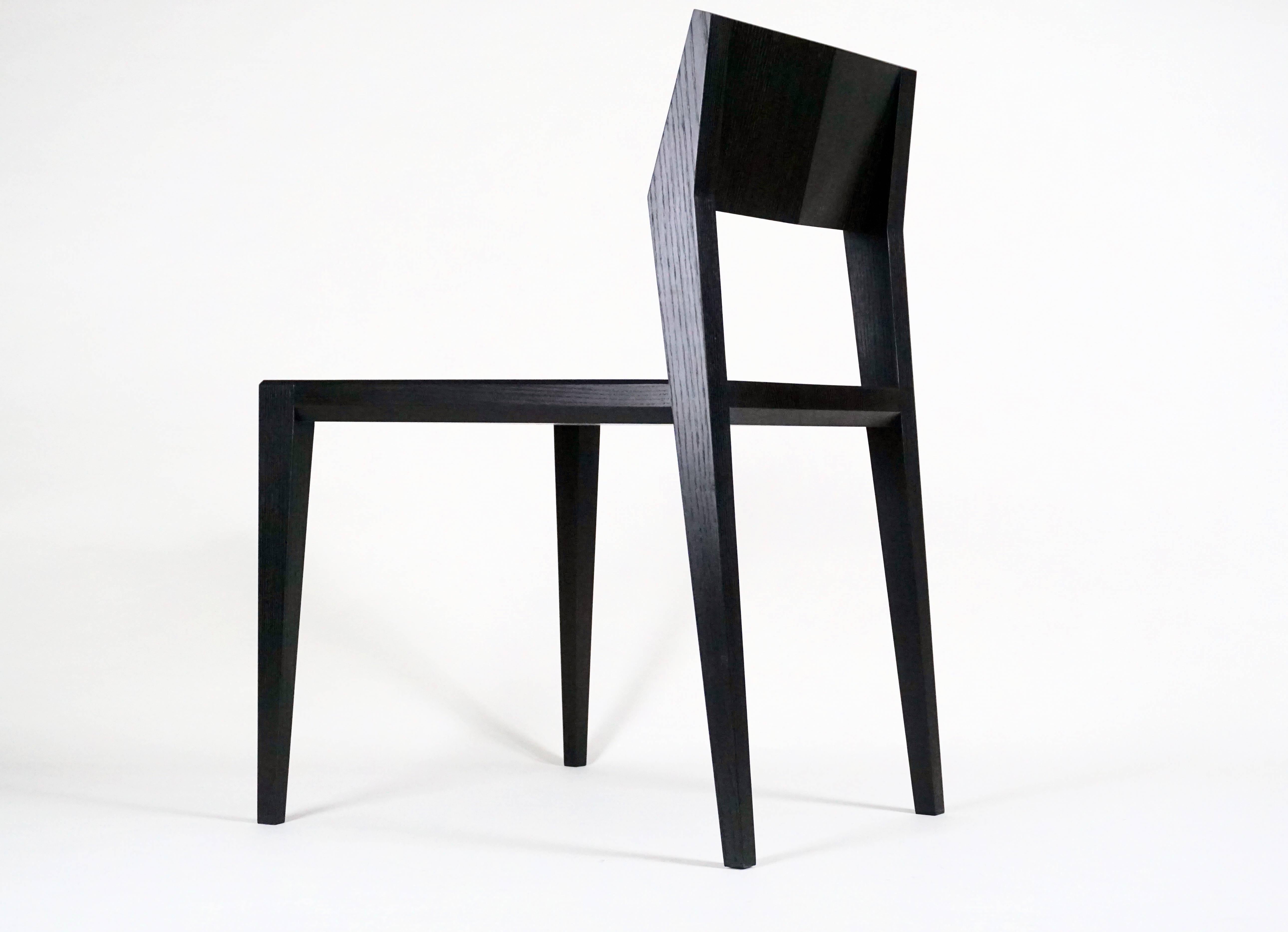 Contemporary solid wood chair with faceted seat back, legs and scooped seat. 

This chair features experimental joinery combining a Maloof joint and Mortise & Tenons with chamfered edges. 

Shown in black satin lacquer finish. Custom finish