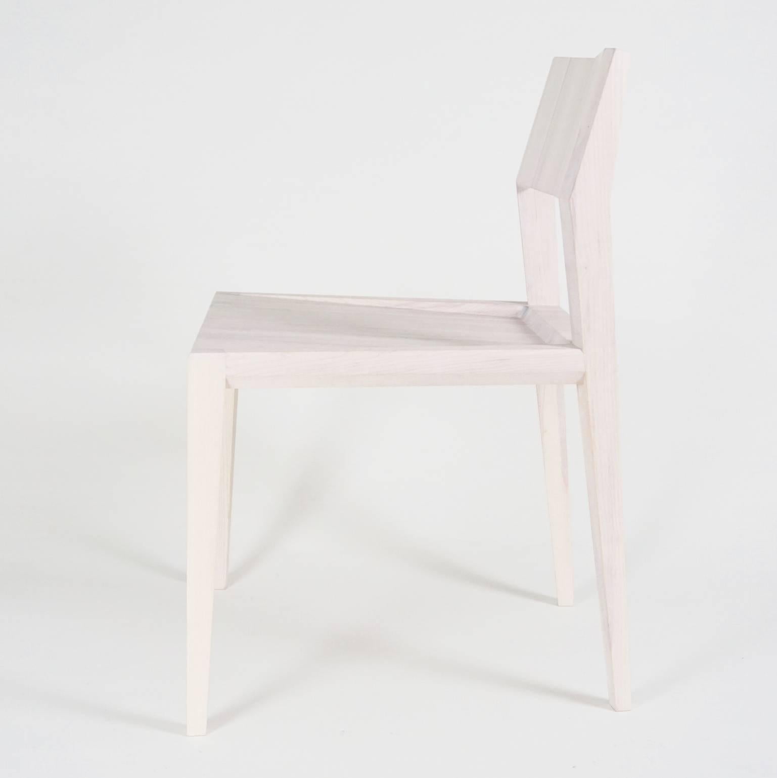 Contemporary solid wood chair with faceted seat back, legs and scooped seat. 

This chair features experimental joinery combining a Maloof joint and Mortise & Tenons with chamfered edges. 

Shown in white laquer finish. Custom finish options -