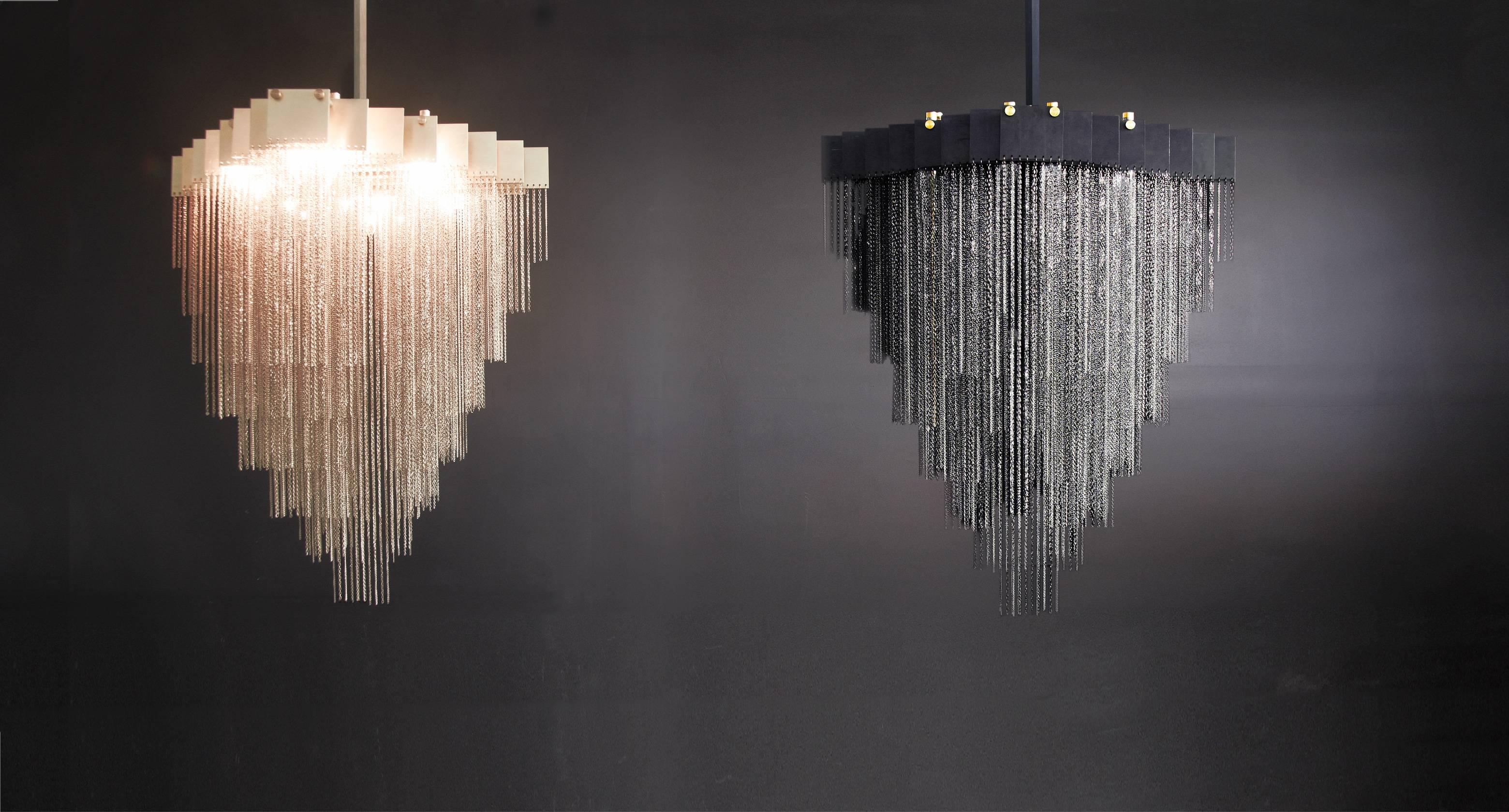 A bold and elegant sculptural light fixture, the Kelly chandelier holds over a half-kilometer of reflective chain to generate a staggered and diametrically exquisite geometrical form. 

Light glimmers throughout the chain for to create a soft