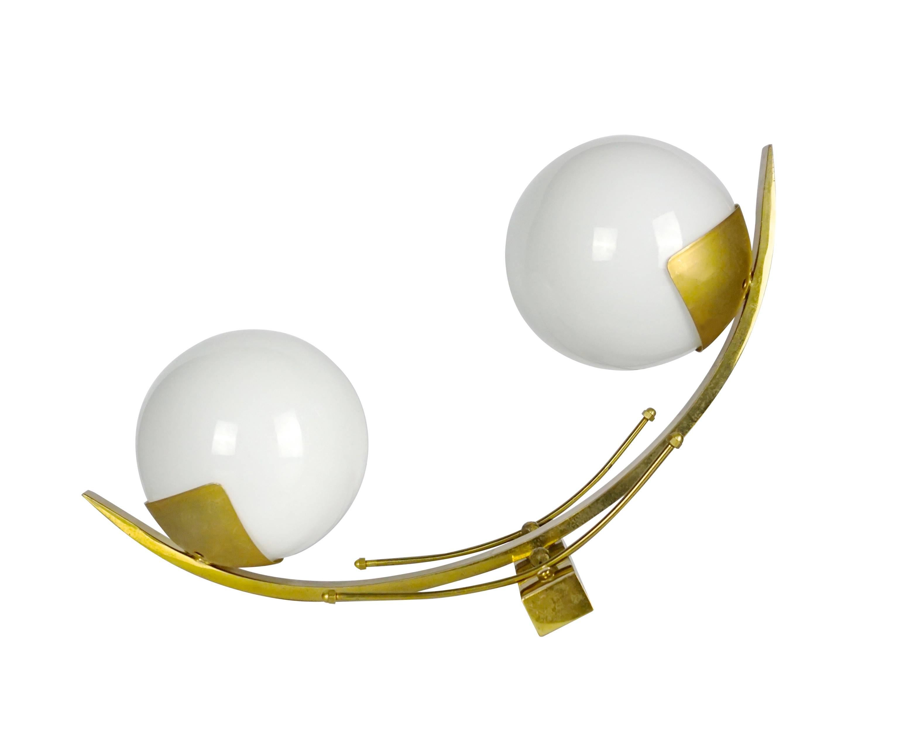 Elegant pair of Stilnovo sconces each holding two opaline glass globe shades and brass frame, circa 1960.