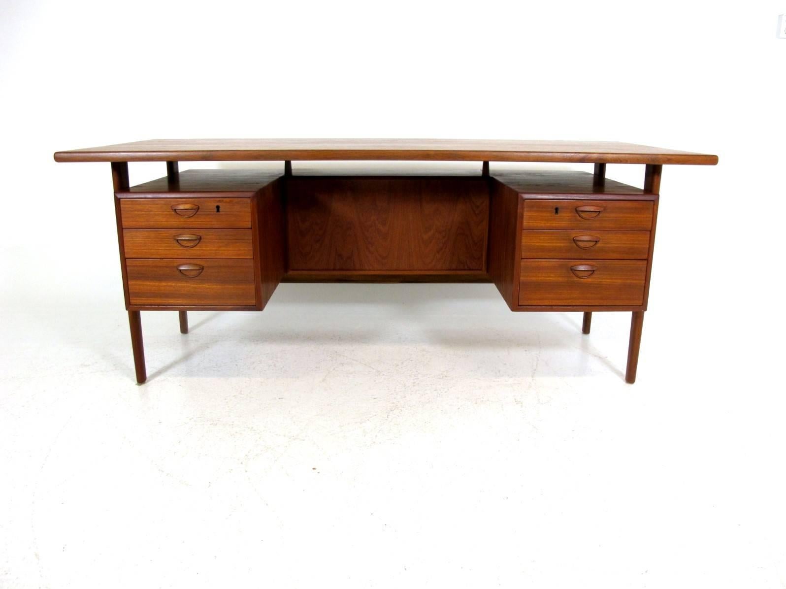 Free standing executive desk with a floating top. Designed by Kai Kristiansen, Model FM60, produced by Feldballes Møbelfabrik in Denmark. Made circa 1960s in teak and with tapered legs.