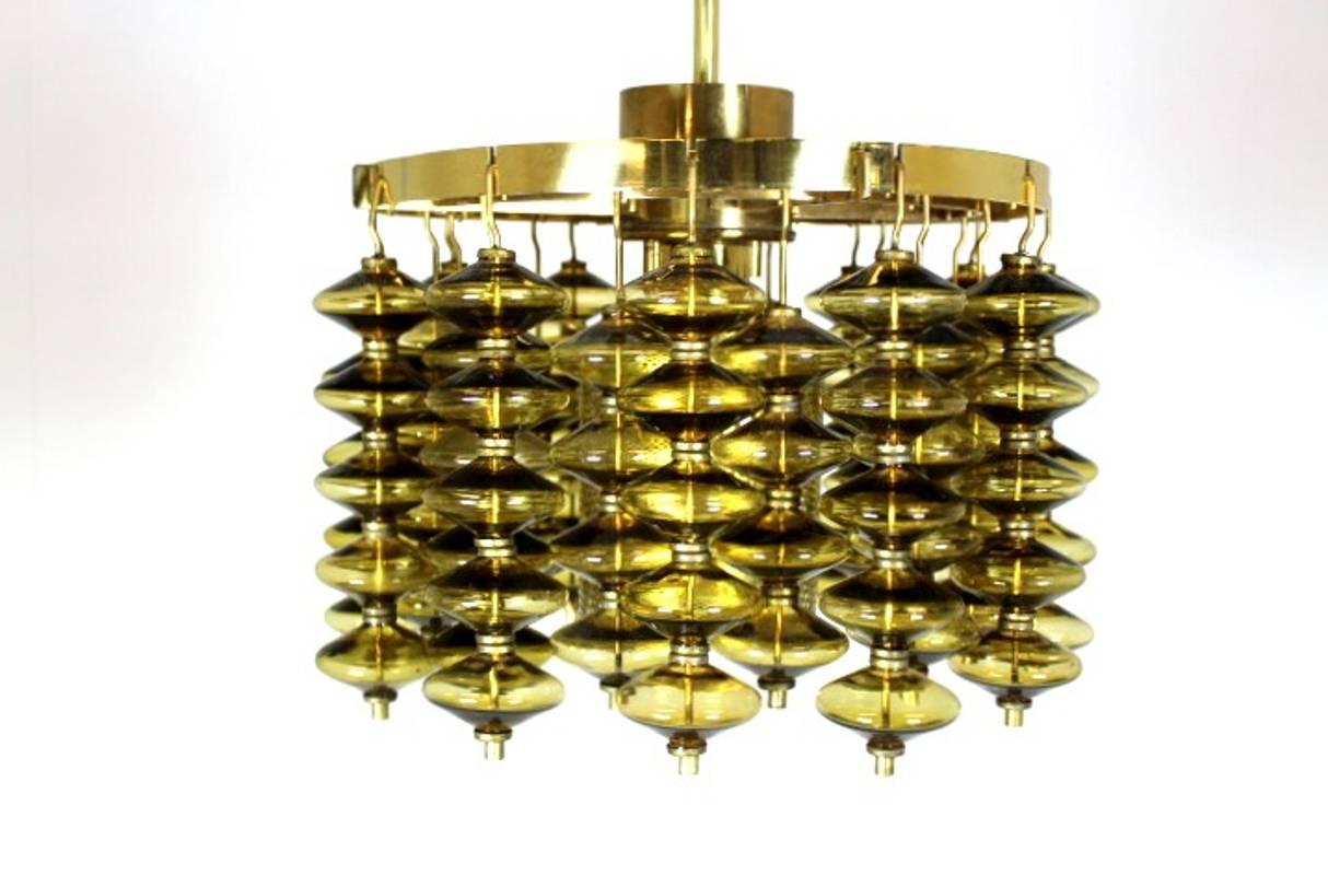 This green glass ceiling light T581/H Estrella with a polished brass back plate was designed by Hans-Agne Jakobsson for Hans-Agne Jakobsson AB, Markaryd Sweden during the 1960s. The piece features glass details strung on brass thread. Hans-Agne