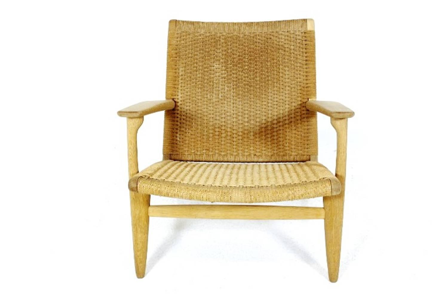 Beautiful Midcentury CH25 lounge chair in wonderful oak with woven papercord back and seat. Designed by Hans J Wegner in the 1950s for Carl Hansen & Søn, Denmark.