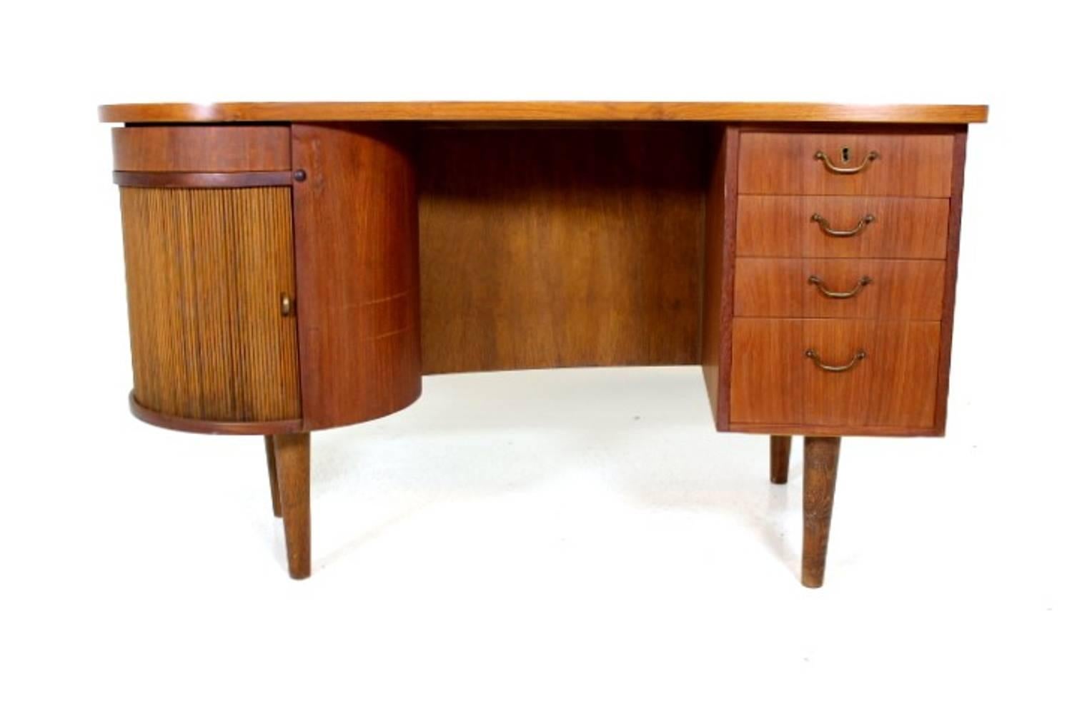 Very rare Scandinavian freestanding desk in teak with bar section and tambourine door.
Mad in the 1950s in Sweden.