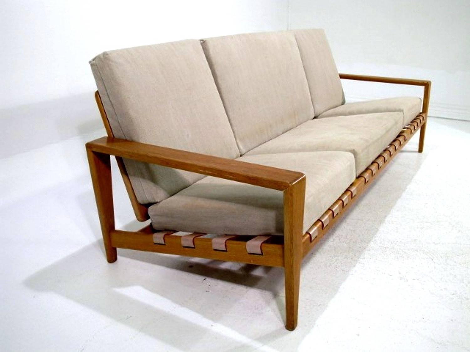 Scandinavian modern sofa designed by Svante Skogh for AB Hjertquist & Co, Nässjö, Sweden. The frame is in oak with leather straps and the cushions with linnen fabric. 
Later fabric with stains.