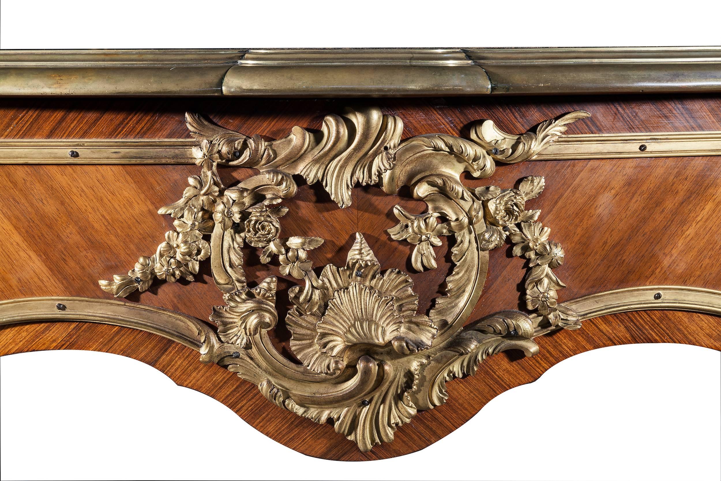 This bureau plat is veneered in bois de rose and decorated by friezes in gilded bronze.
Stamped: P. Sormani, 10 rue Charlot

The top is contoured, covered in brown leather and sharpened by a gilt bronze edge with plant decorations at the corners.