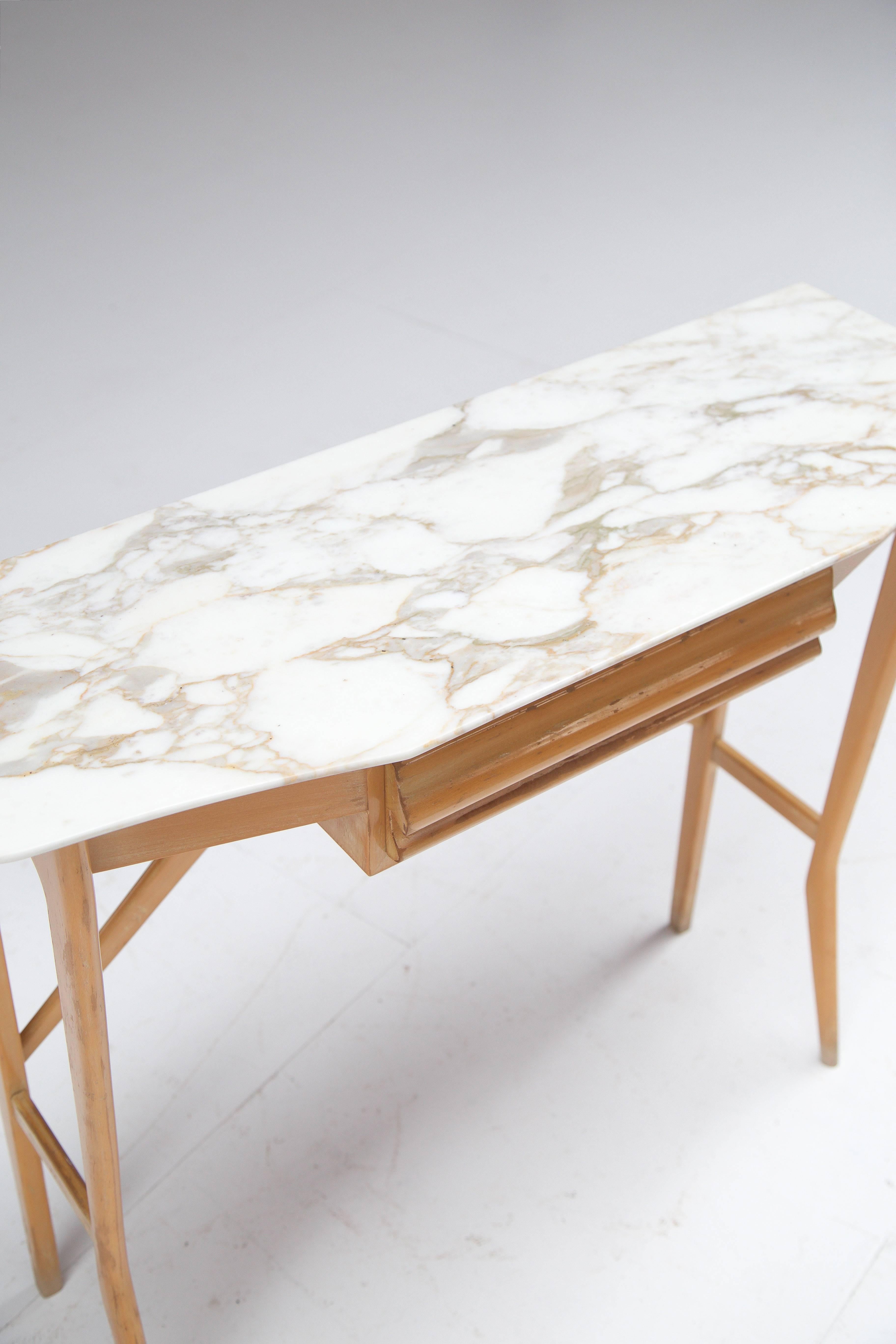 Wooden console supporting a Carrara marble top. 
Typical Italian finesse with slender feet and a very stylish appearance.