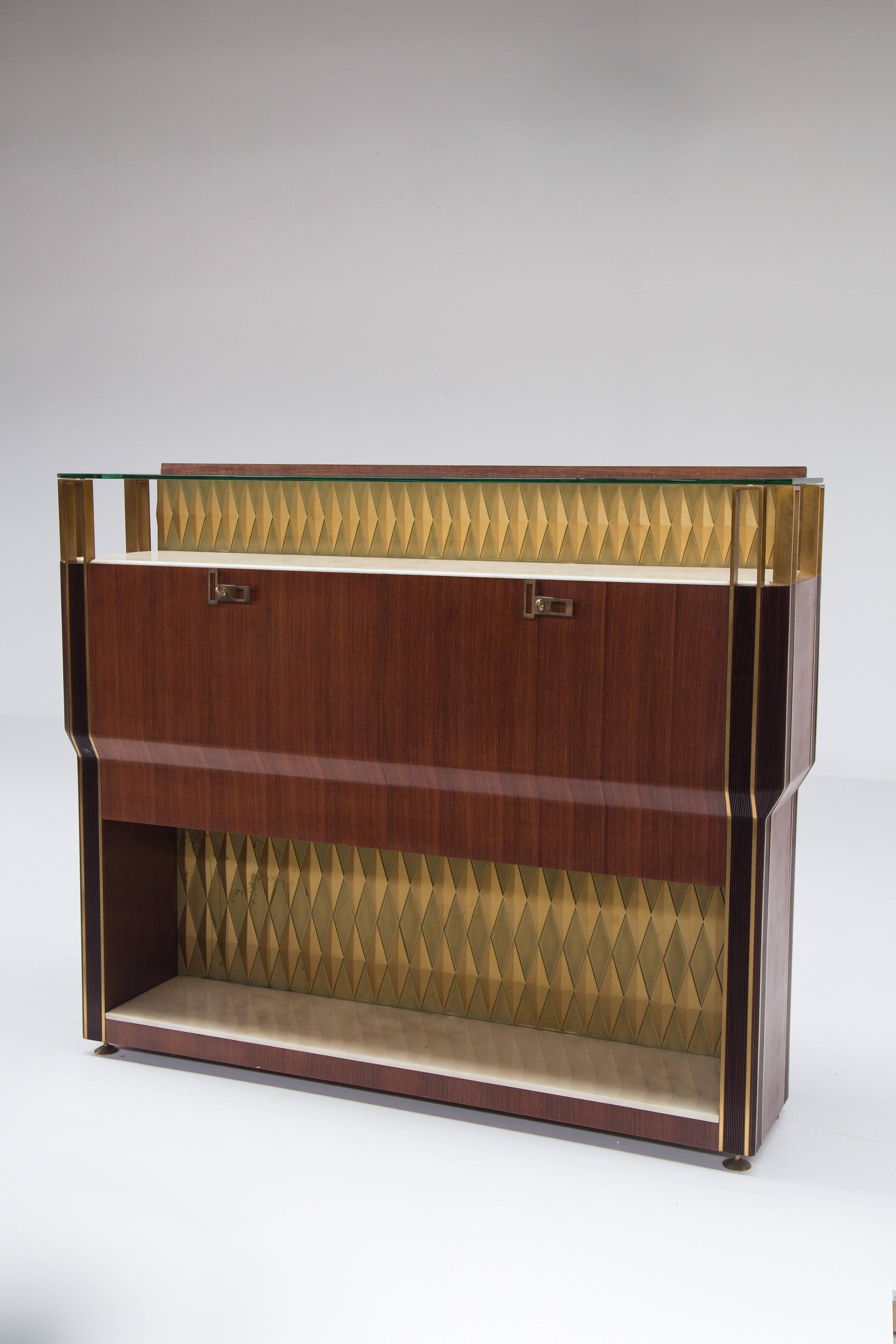 Exceptional bar cabinet in rosewood with brass fittings, decorated with bicolor lozenges, upper top in glass and lower top in marble top, it has interior lighting when open. Procucer: Consorzio Esposizione Mobili Cantù.