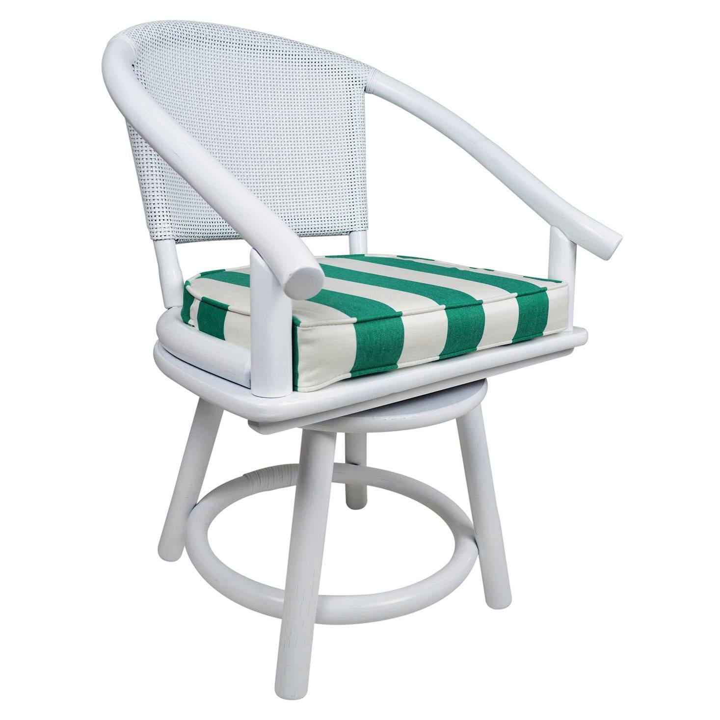 Vintage Ficks Reed swivel chairs newly lacquered in white. The removable cushions are newly upholstered in an emerald green and white stripe indoor/outdoor fabric.
