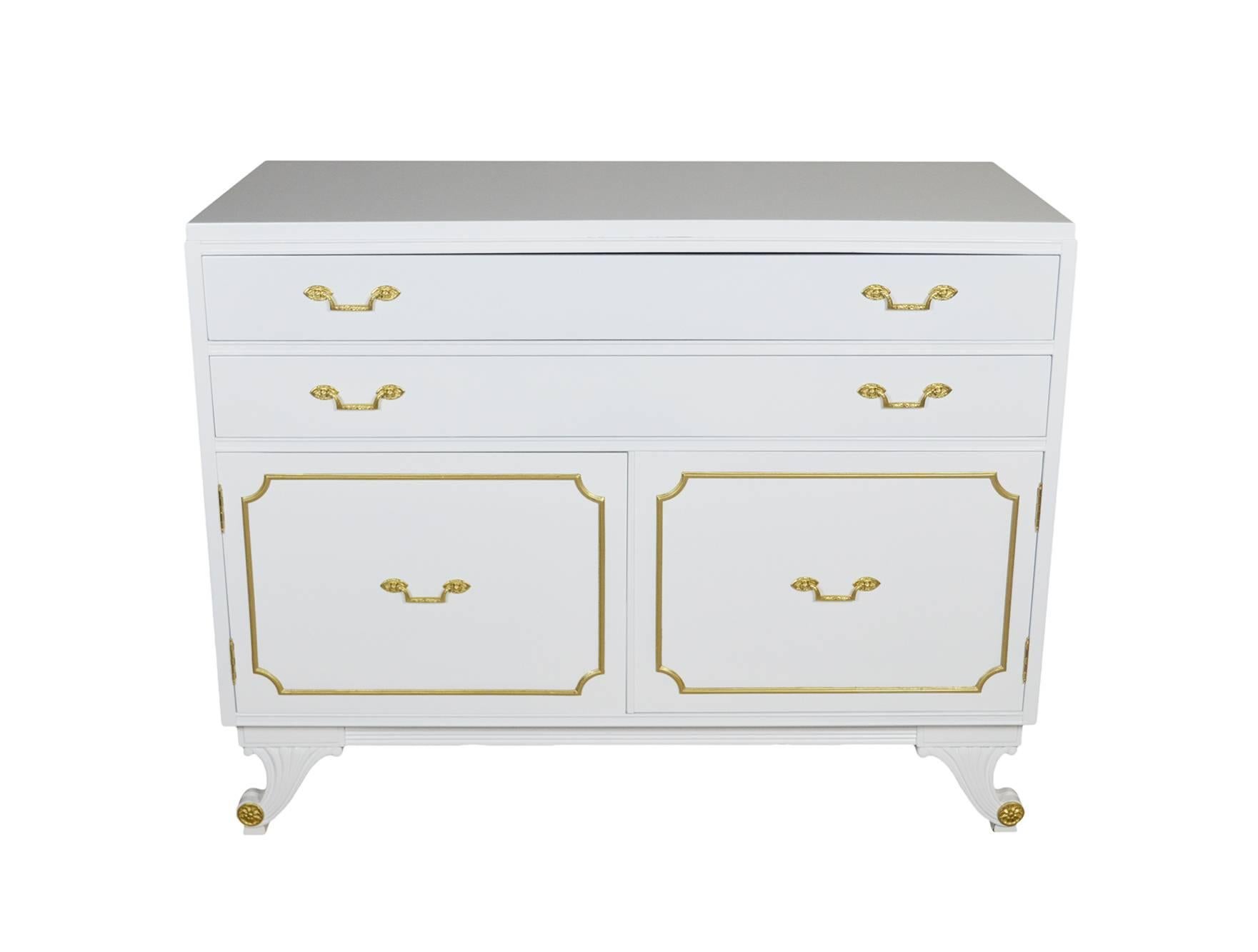 VIntage neoclassical style cabinet by RWAY newly lacquered in white. The cabinet has two drawers and a shelf inside the cabinet doors with brass hardware.