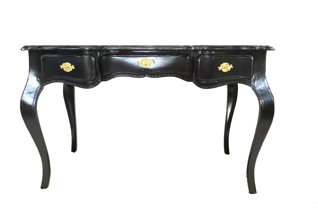 Vintage French-style desk newly lacquered in black and attributed to La Barge. Incised lines on the top form a lattice pattern, with a carved design bordering the legs and apron with three drawers and brass hardware. Measure: Knee height 24
