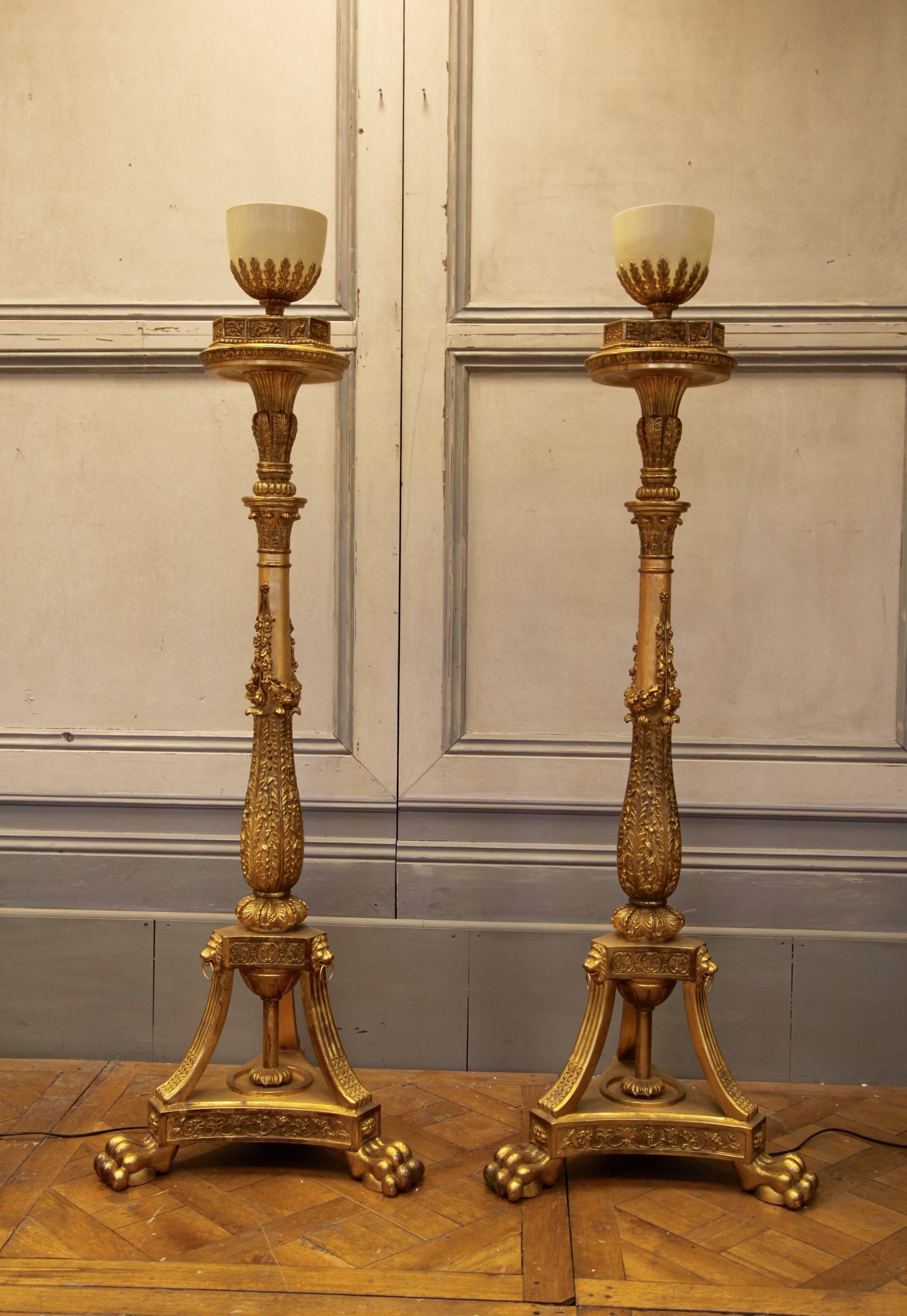 Impressive Louis XVI style torchere bases with up lighters. Beautifully hand-carved and gilded by hand using traditional methods in an antique finish.