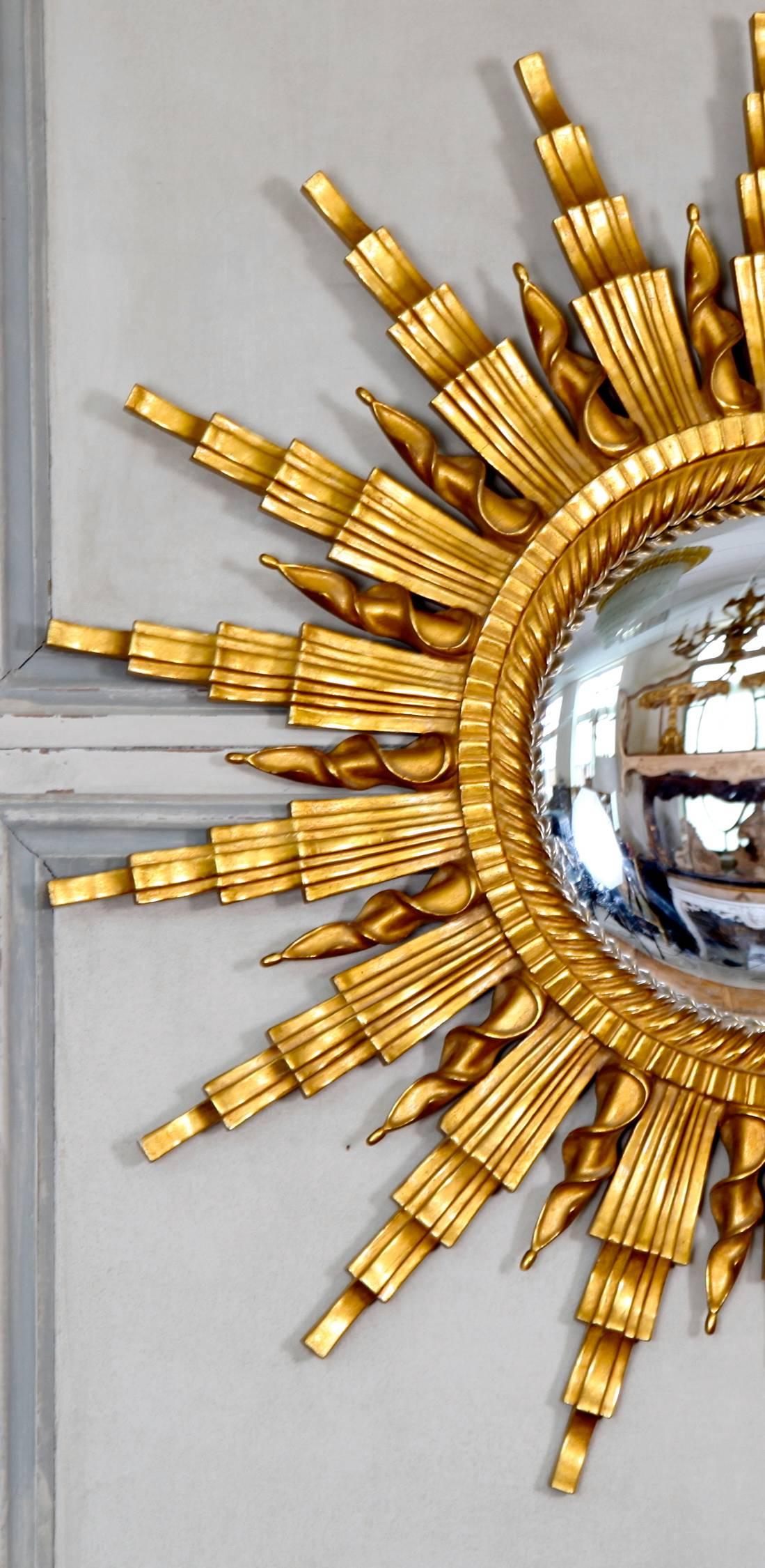 Hand-carved mirror frame with a convex glass. Hand gilded using traditional methods and materials.