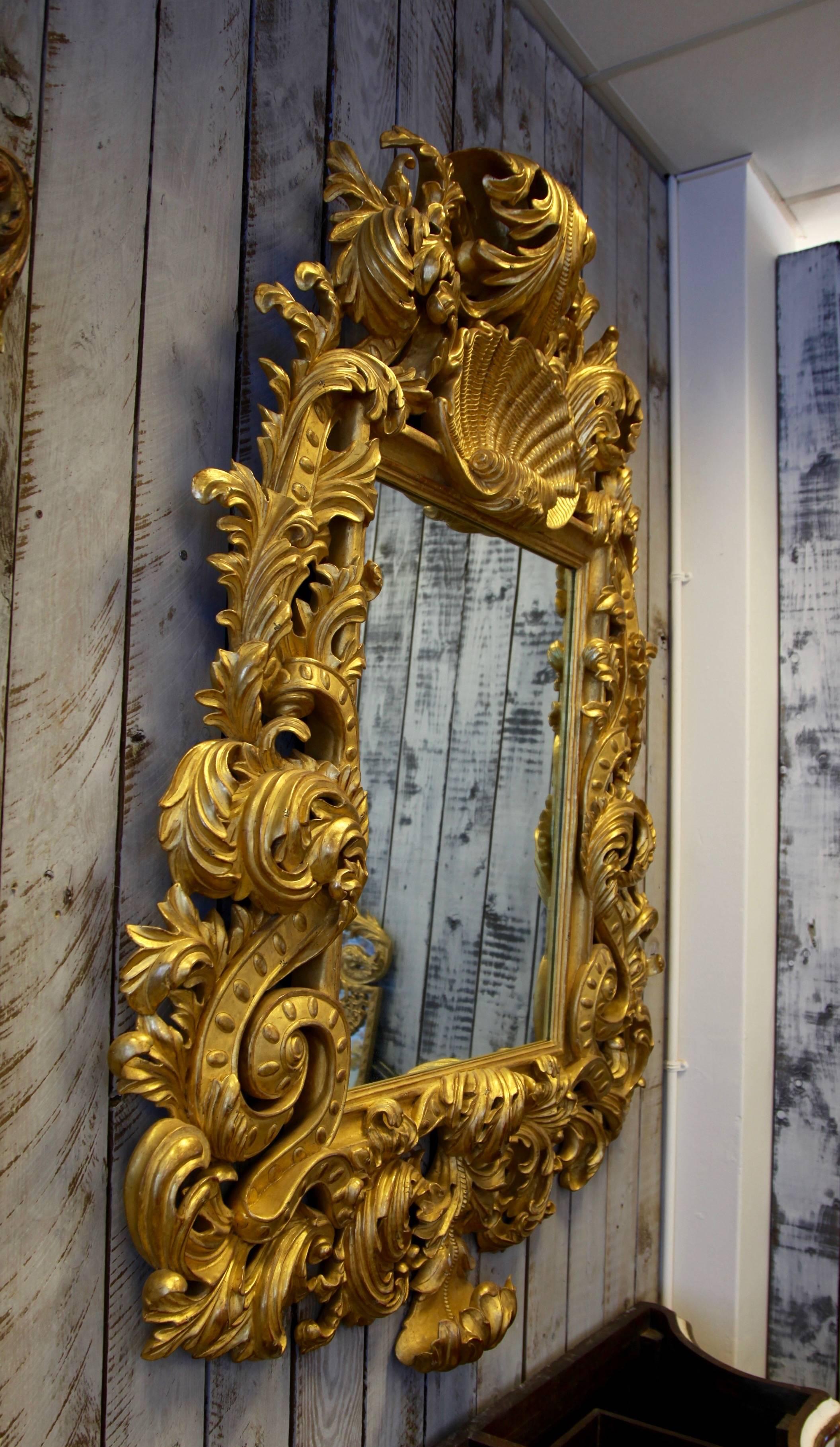 Hand carved Baroque style mirror with exceptional detailing, finished in hand applied 23.75-karat gold leaf.
We have 2 available.
