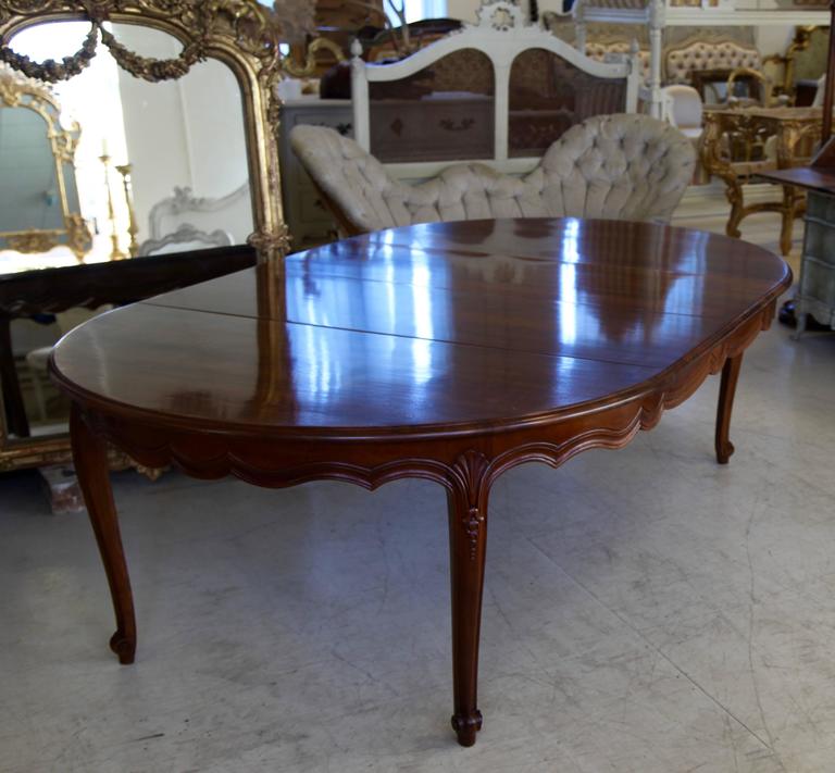 A classic reproduction of a Louis XV style dining table, hand-carved in solid French walnut by La Maison London made in the spirit of Jansen with a lightly aged/distressed patina. 
The table consists of two table ends, each of 75cm, and three