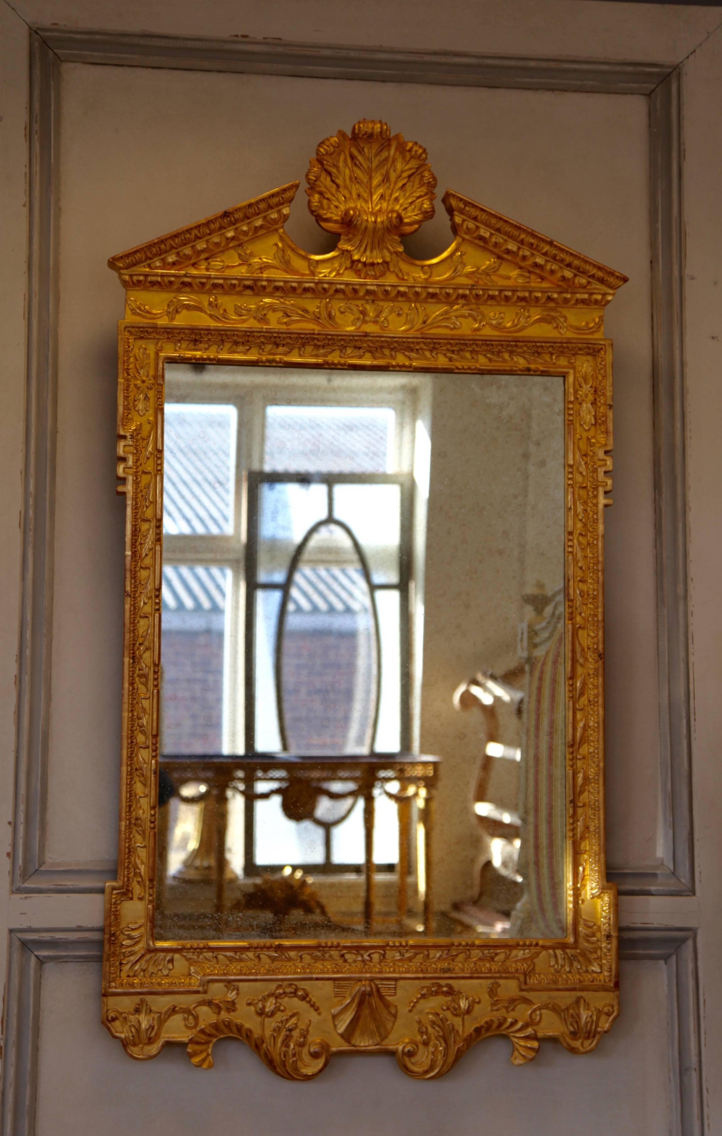 Georgian style, hand-carved mirror finished in traditionally applied gold leaf with light, antique patina.