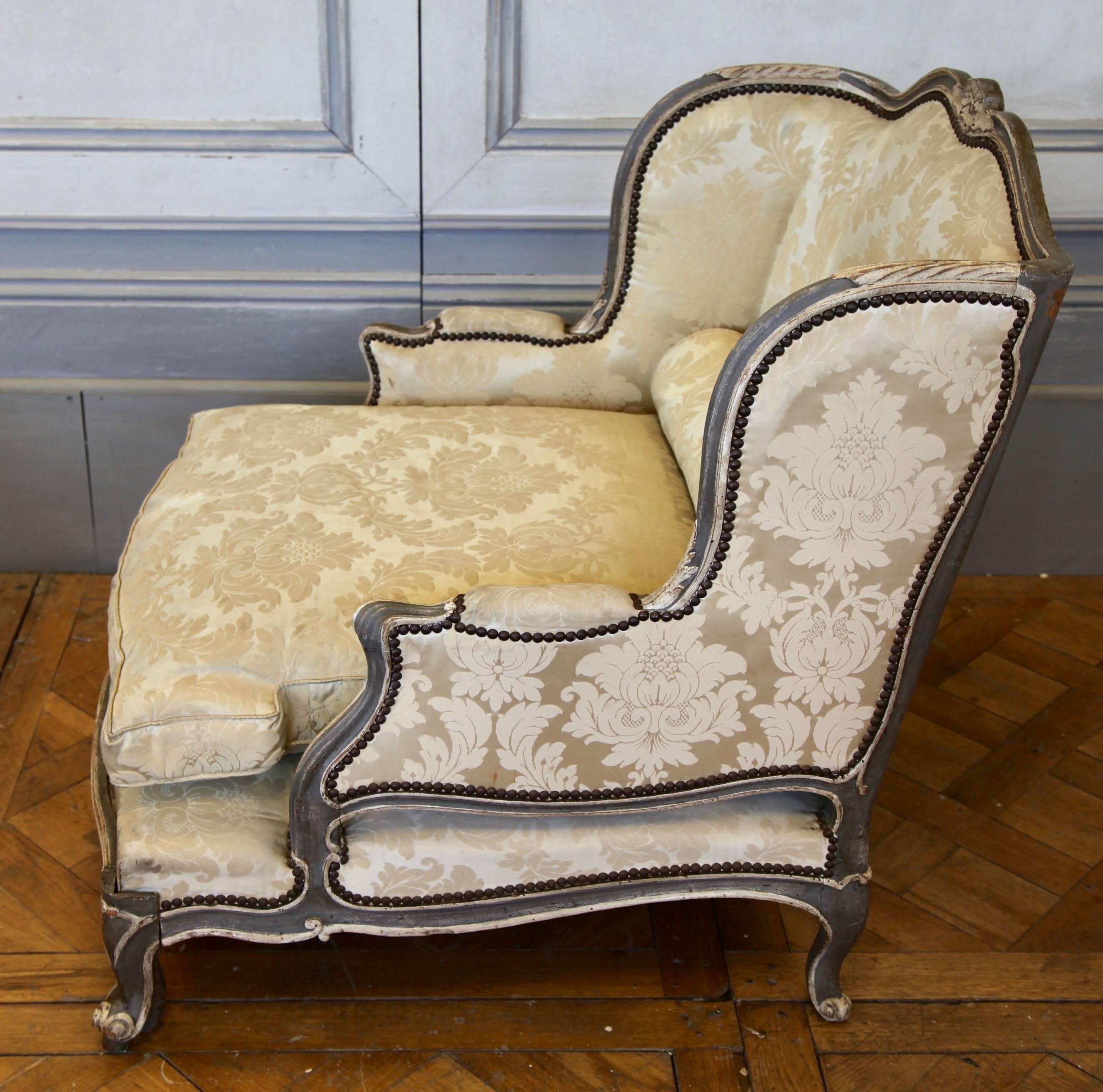 A Louis XV style Bergère chair with a built in section at the base which pulls out to become a duchesse when required. An unusual and innovative design for the period. Finished in the original two-tone paint colors of grey and ecru as seen in the