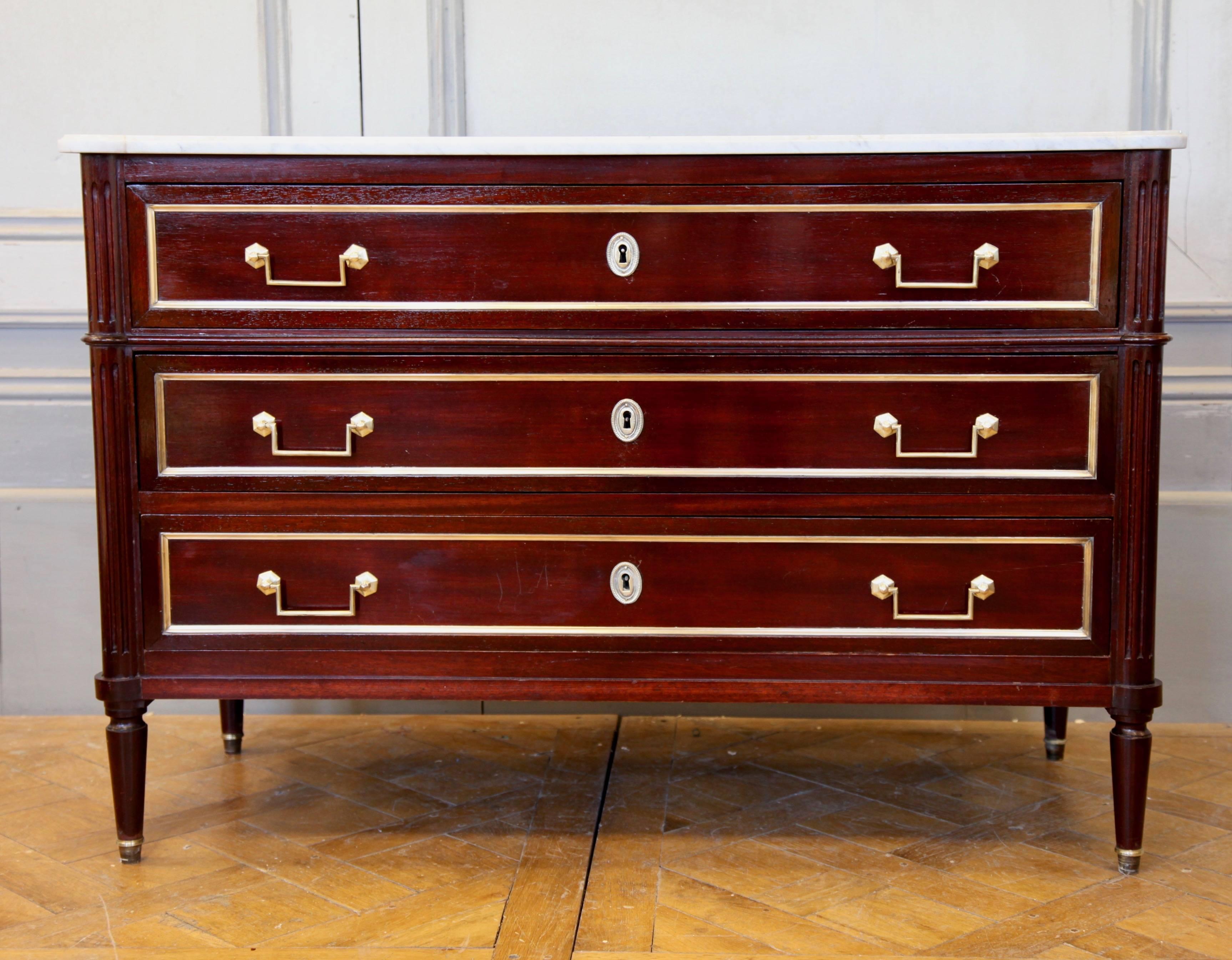 Classic styling. French Louis XVI style commode, circa19th century. Made in solid mahogany finished with bronze handles and beading. Original beveled white Carrara marble top.