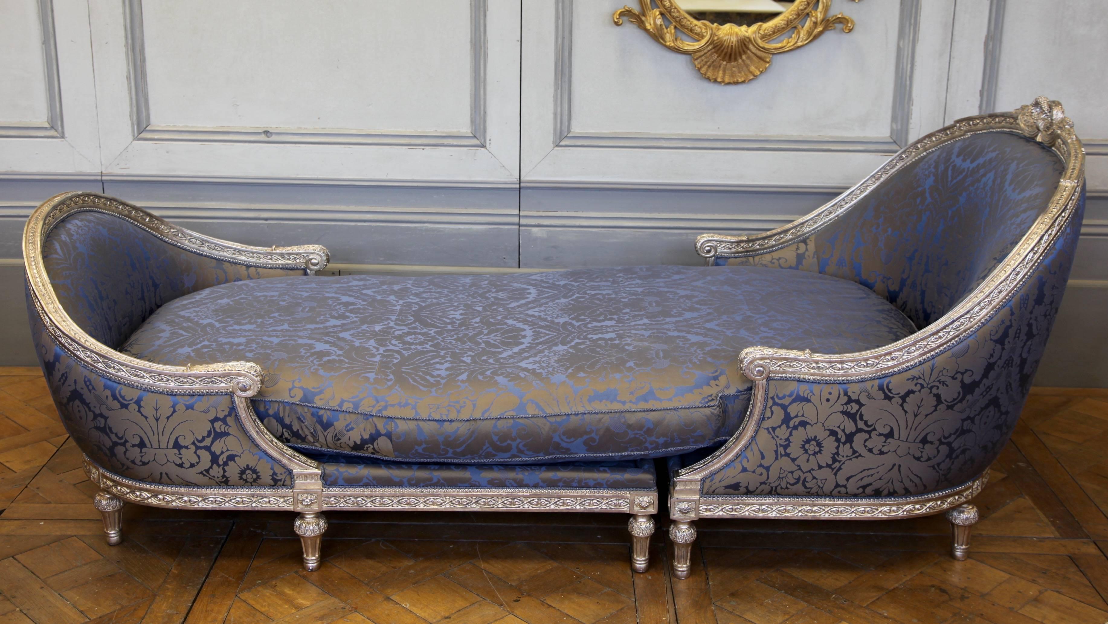 An impressive, statement piece, Louis XVI style chaise longue based on an antique chair from Coco Chanel's apartment. Hand-carved and hand finished in sterling silver leaf. Fully upholstered in a complementary damask fabric.