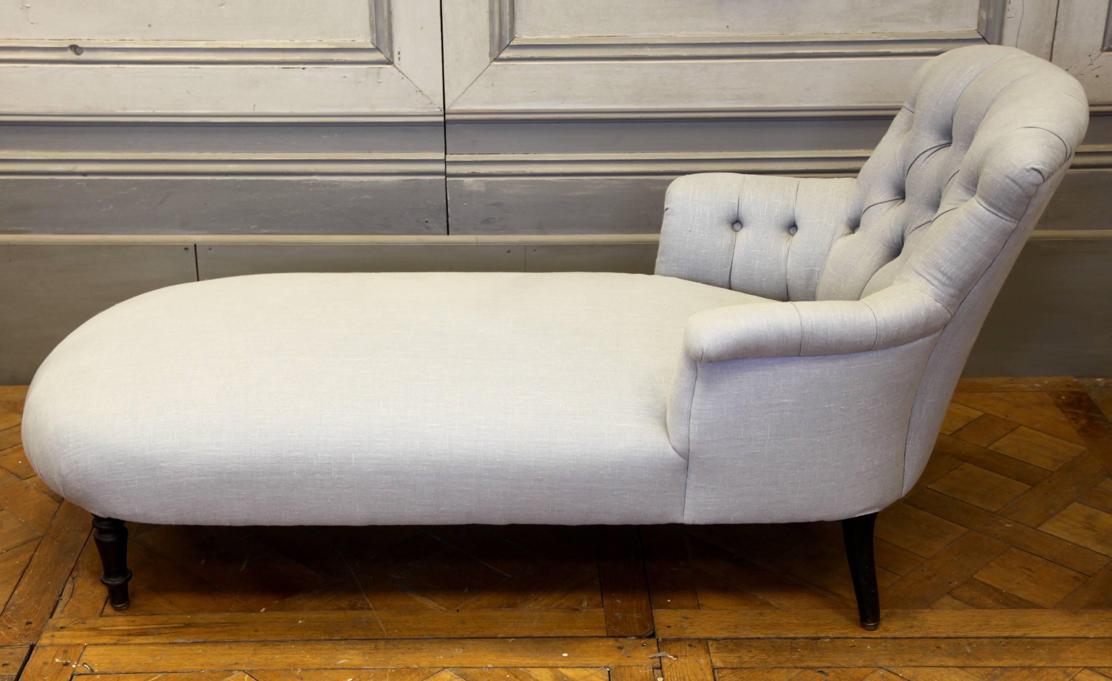 French chaise longue, circa 1870s. Original turned legs and reupholstered in French grey linen with deep buttoned arms and backrest.