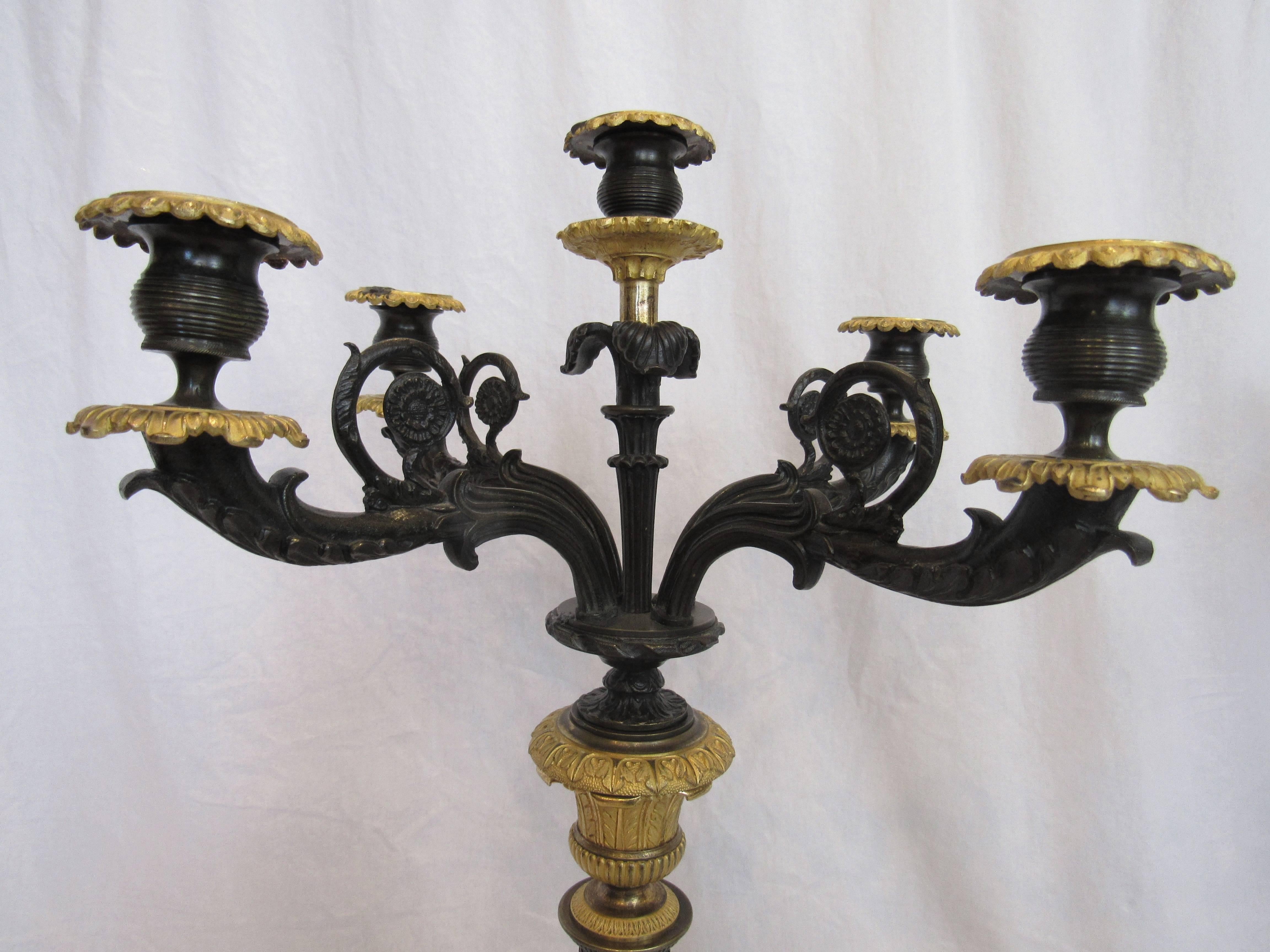 Pair of five-light candelabra. French bronze and ormolu. 19th century.

Empire style, large-scale with paw feet and bronze doré accents. Beautiful condition.

Measures: 28" total height by 15" by 15".