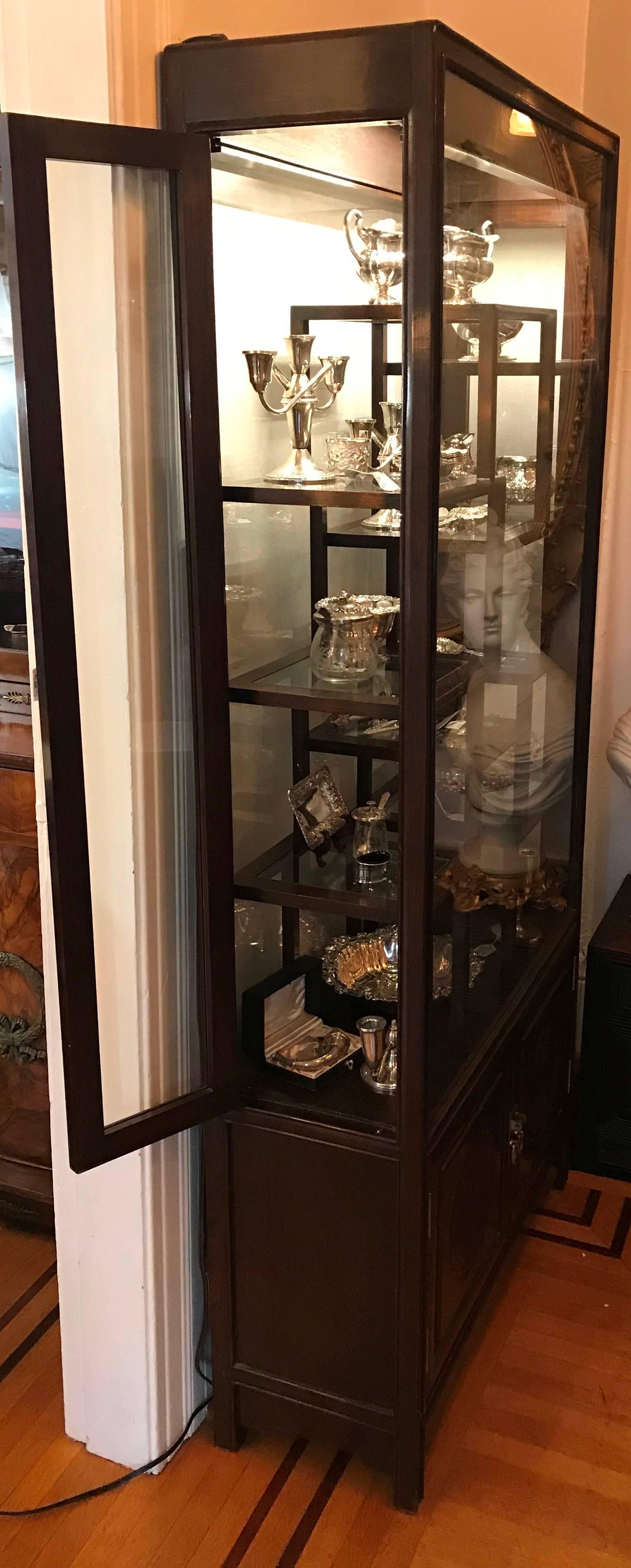 Chinese collection cabinet. Dark wood with glass front and back. Can be viewed or displayed from both sides.

Interior with 10 various size framed glass shelves. Two-door lower cabinet. Interior accessed from a single door on either side.

20th
