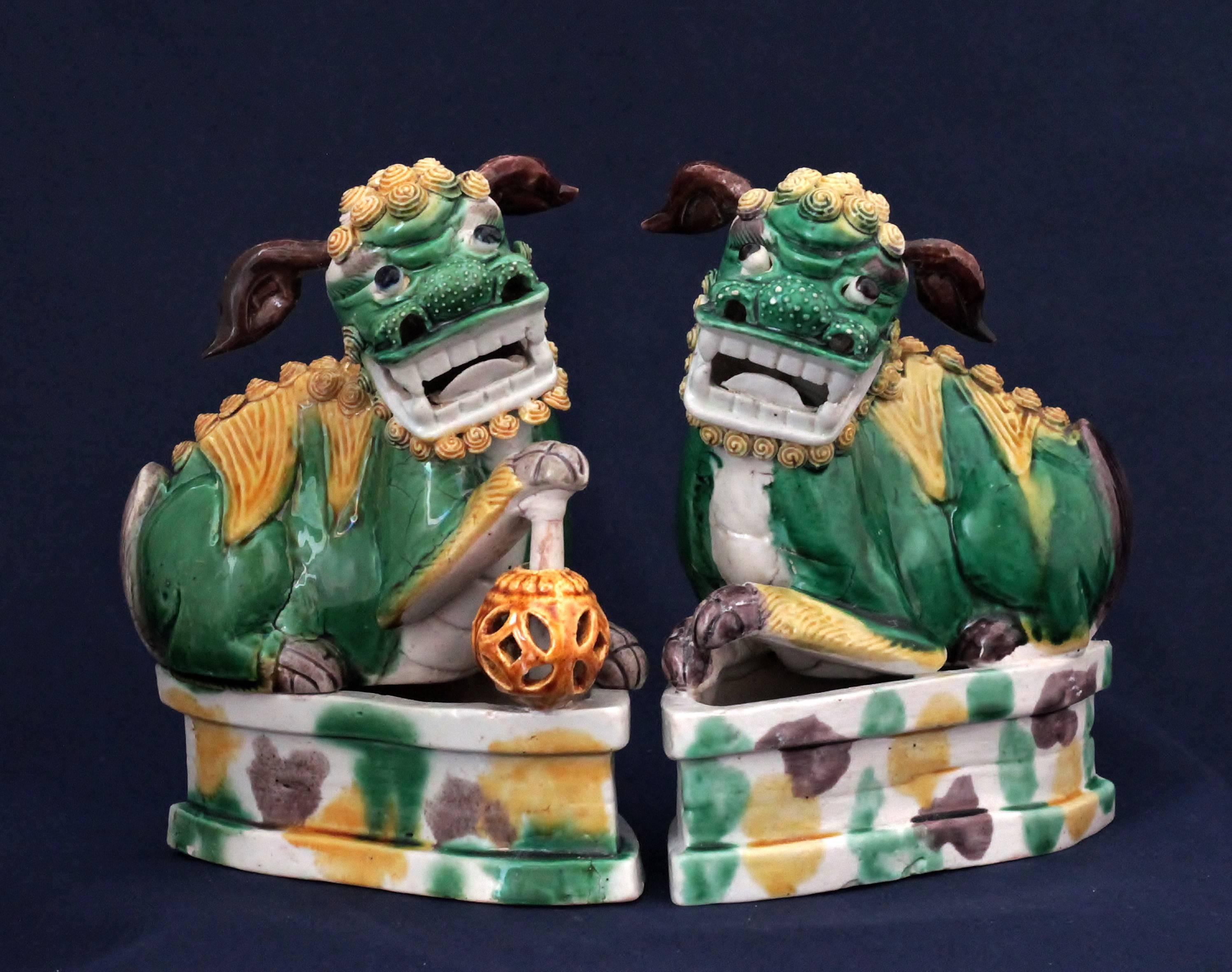 A pair of Buddhist lions said “shi-shi” in enamelled biscuit with “Harlequin” colors (yellow, green and brown). The lions are slept on the bases, the ears and the ball are moving.
Measures: Height: 15.3 cm, width: 13.5, depth: 8 cm.
One ear