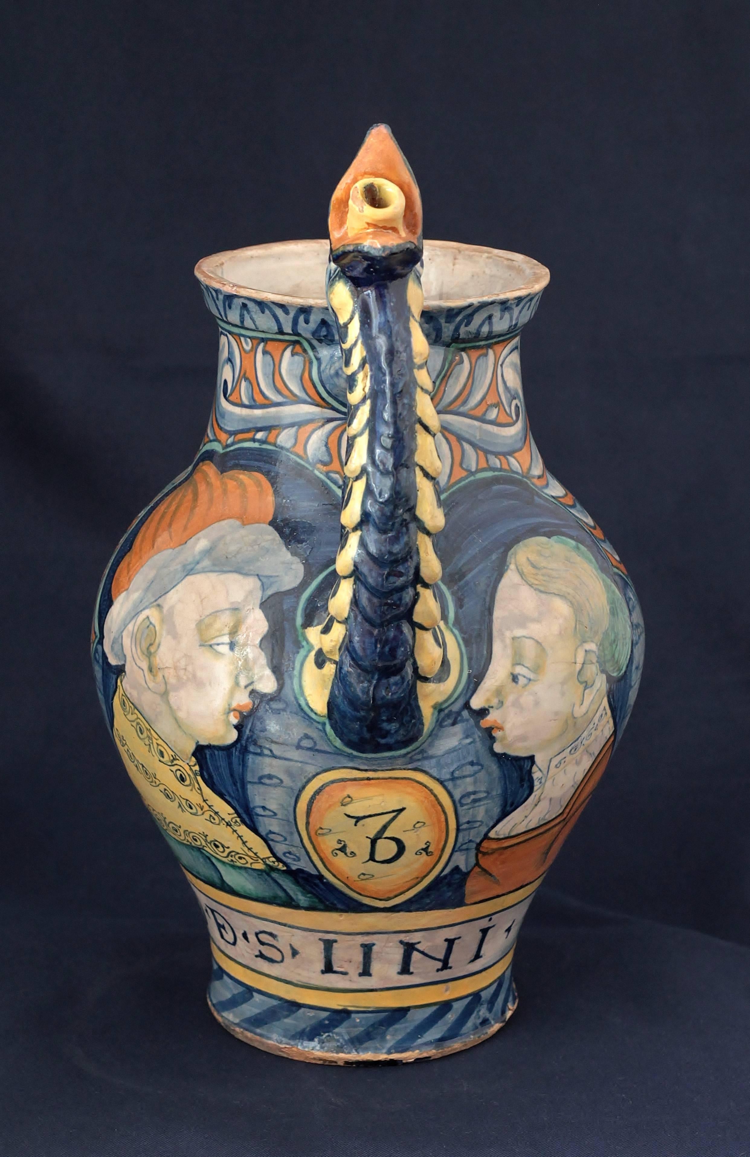 A Castelli (Italy) Majolica chevrette with polychrome decoration of two figures a man and a woman. Apothecary inscription “O.D.S.LINI.”. Orsini-colona, work of Pompei, circa 1545-1550, 16th century. Measures: Height: 28 cm, diameter: 21 cm.