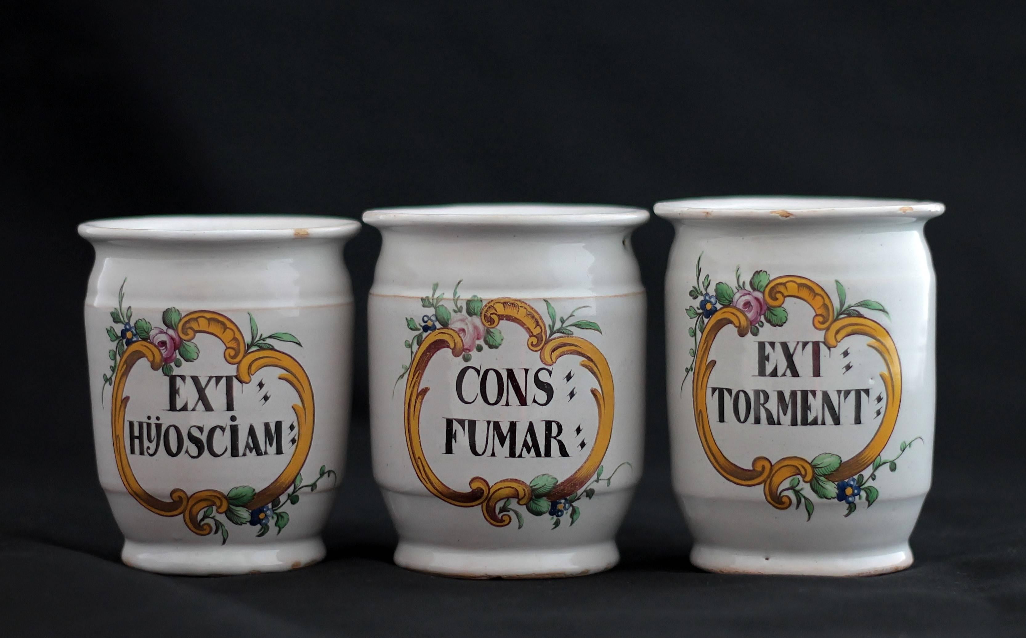 Hagueneau (France, Est) faience, three pillboxes with a polychrome decoration of a rocaille cartouche decorated with rose, blueberry and foliages. Inscriptions : “EXT : HÿOSCIAM (extrait de Jusquiame) ; CONS : FUMAR (conserve de fumeterre-herbe) ;