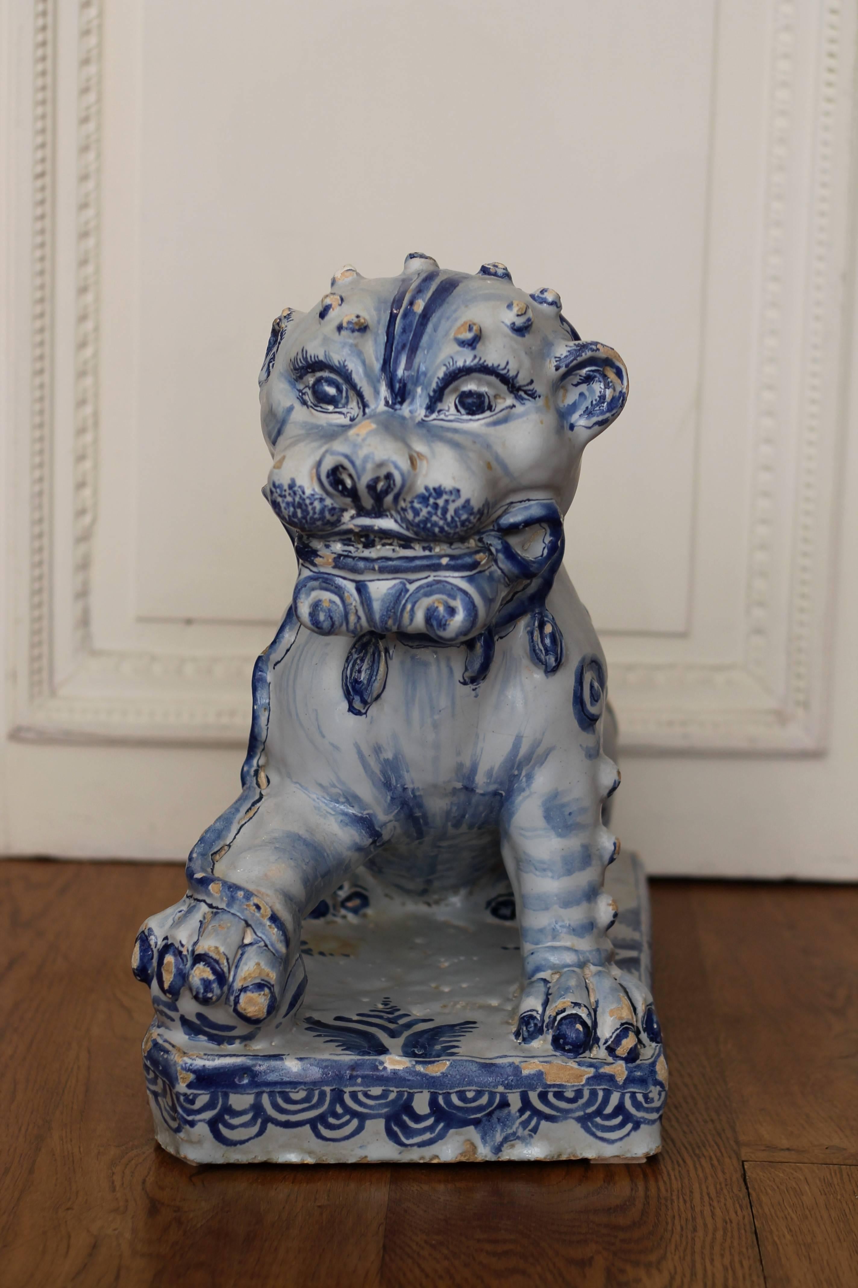 Lion in faience of Nevers, France with blue decoration. Middle or second part of 17th century.
Measures: Length 40 cm, width 22 cm, height. 40.5 cm. Several lacks of enamel visible.
Inspired by China, the lion resting its leg on a ball (which in