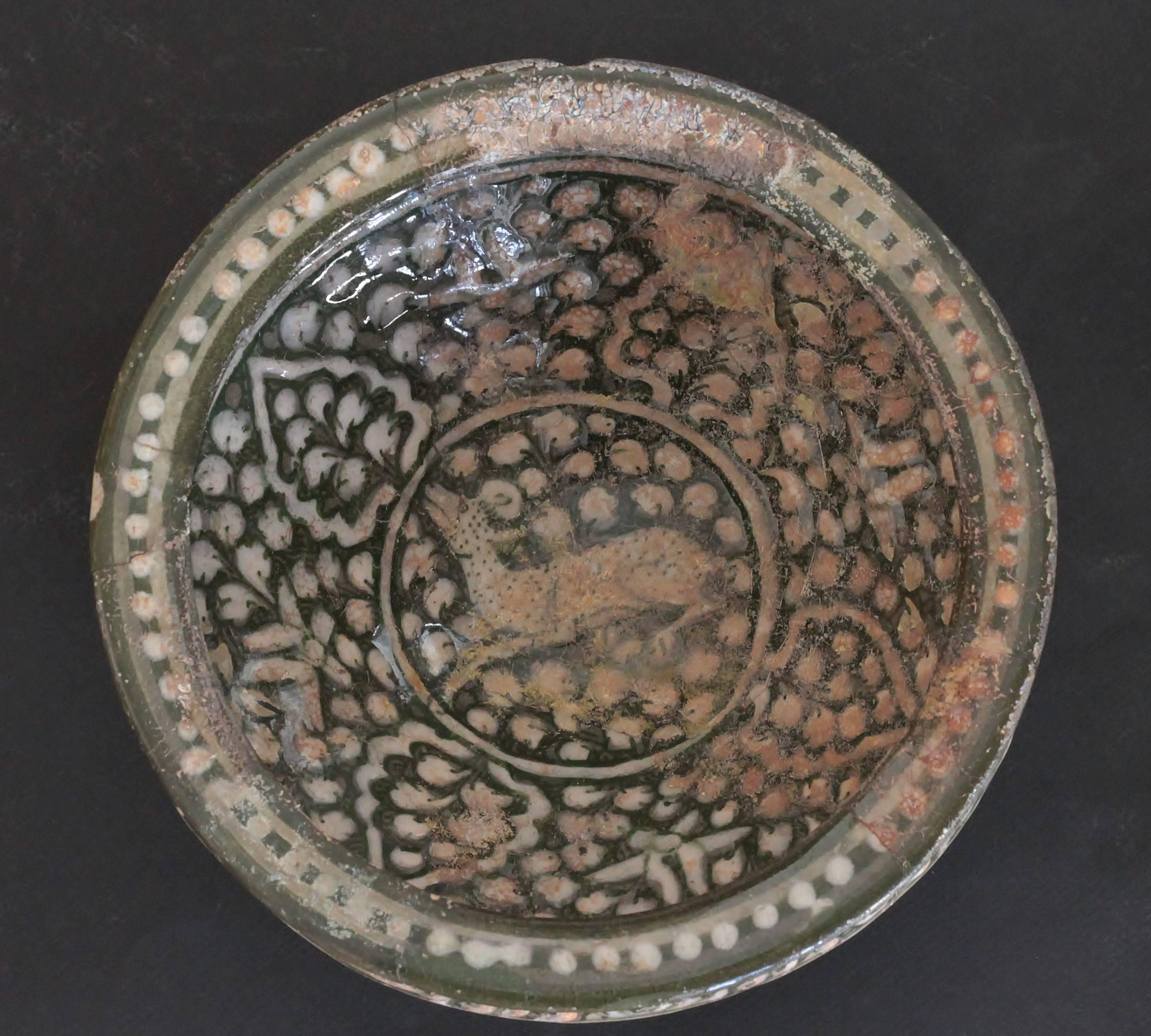 Bowl tronconique ceramic decorated in white on green bottom of one goat in the centre of sheet, flowers and pearls. So called inscription on the border.
Art Ilkhanide (1256-1353), Iran 12th and 13th centuries.
Measures: D. 22 cm. H. 11, 6 cm. Some