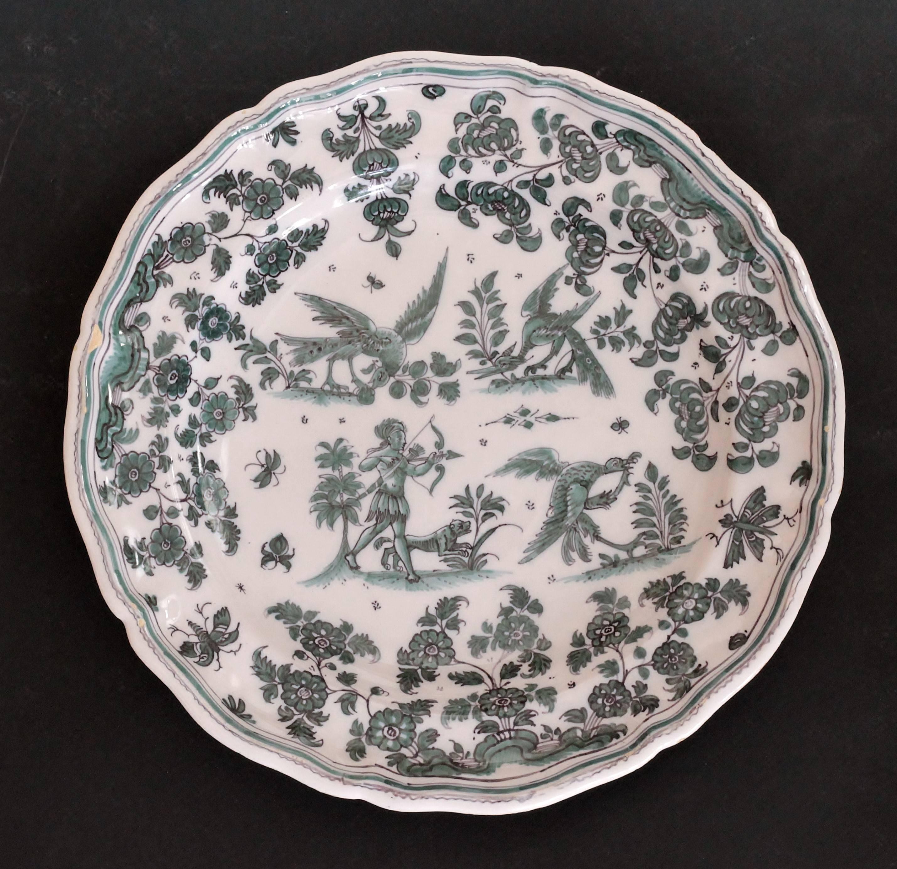 Earthenware plate decorated in shades of green of grotesque fantasy animals on four terraces surrounded by flowers and foliage
Marked: 
