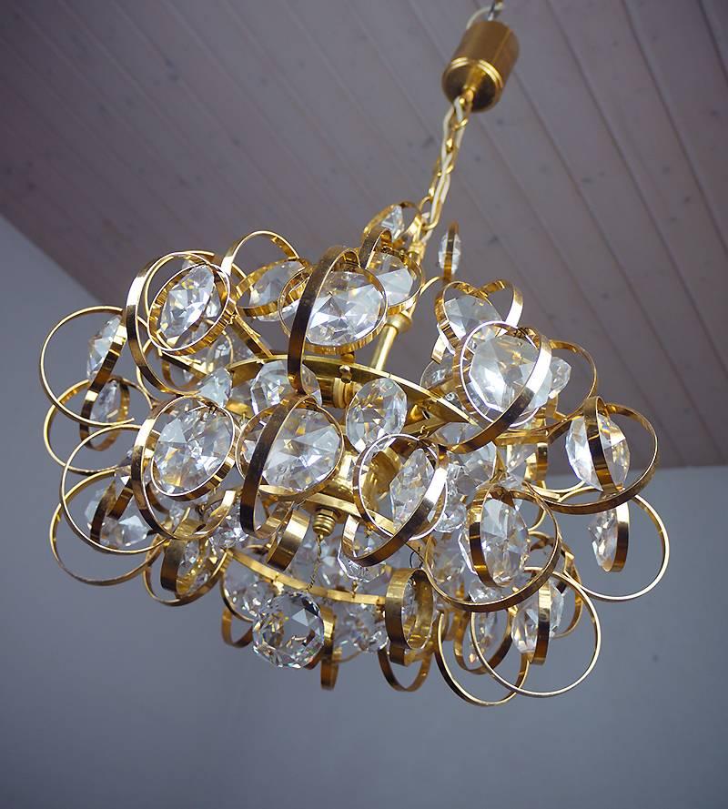 Elegant sputnik chandelier with crystal glasses suspended in gold-plated brass circles designed by Gaetano Sciolari. Chandelier illuminates beautifully and offers a lot of light. Gem from the time. With this light you make a clear statement in your