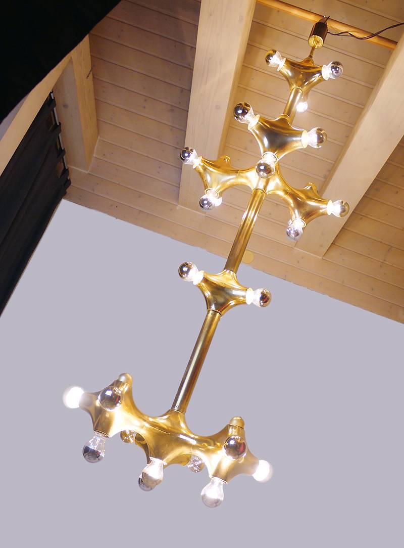 This spectacular 67″ in. space age statement light designed by Cosack Bros. is the perfect center piece for a loft, lobby, foyer or a hotel and company entrance. It is made of twenty-five large organic golden lighting elements around a brass bar. A