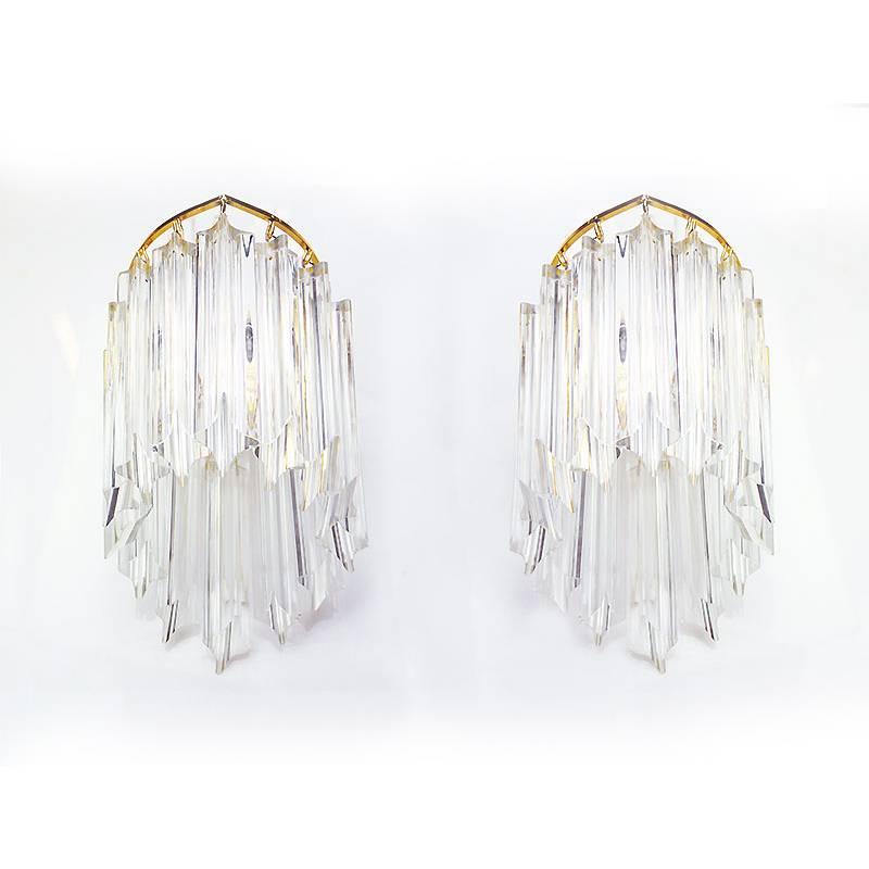 Elegant wall sconces with crystal glass prisms on a gold-plated brass frame. Manufactured by Novaresi, Italy in the 1970s. 
 
Designed by Venini Camer attr. 
Manufacturer: Novaresi. 
Lighting: takes one small Edison E14 base screw bulb per lamp.