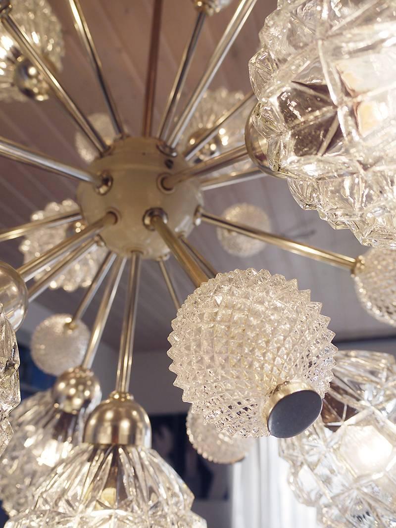 Elegant large sputnik chandelier with 25 arms ending in 13 large crystal globes and 12 smaller crystal balls on a white enameled frame with chrome finals. Designed by Richard Essing. Chandelier illuminates beautifully and offers a lot of light. Gem