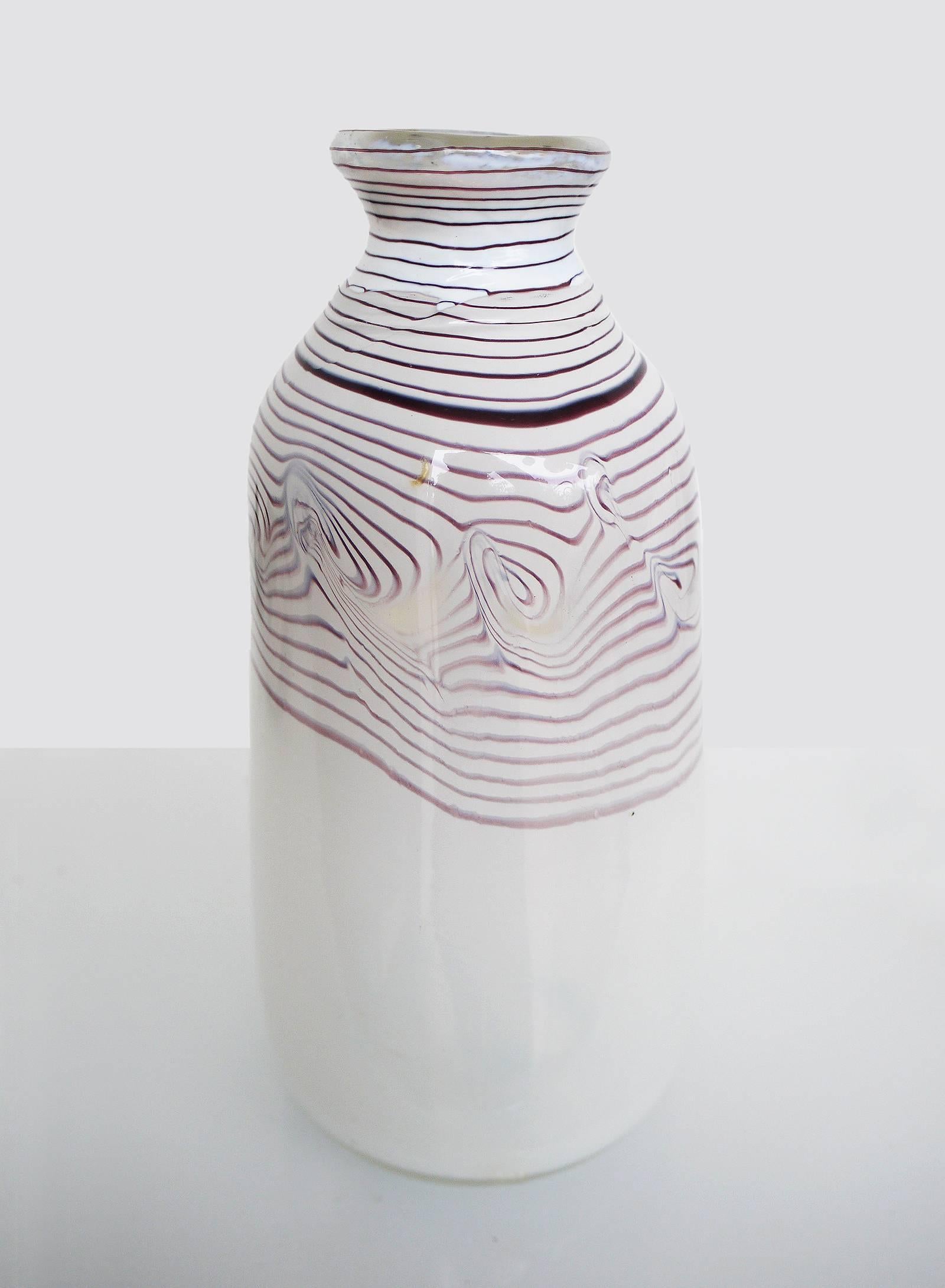 Milchglasvase mit lila Fadeneinschlüssen. Erwin Eisch (geboren 1927 in Frauenau, Deutschland) ist einer der Begründer des Studioglases in Europa. Die Vase stammt aus den 1970er-1980er Jahren, unten mit eingeritzter Signatur.
Gewicht: 1262 g/2.78 lb. 