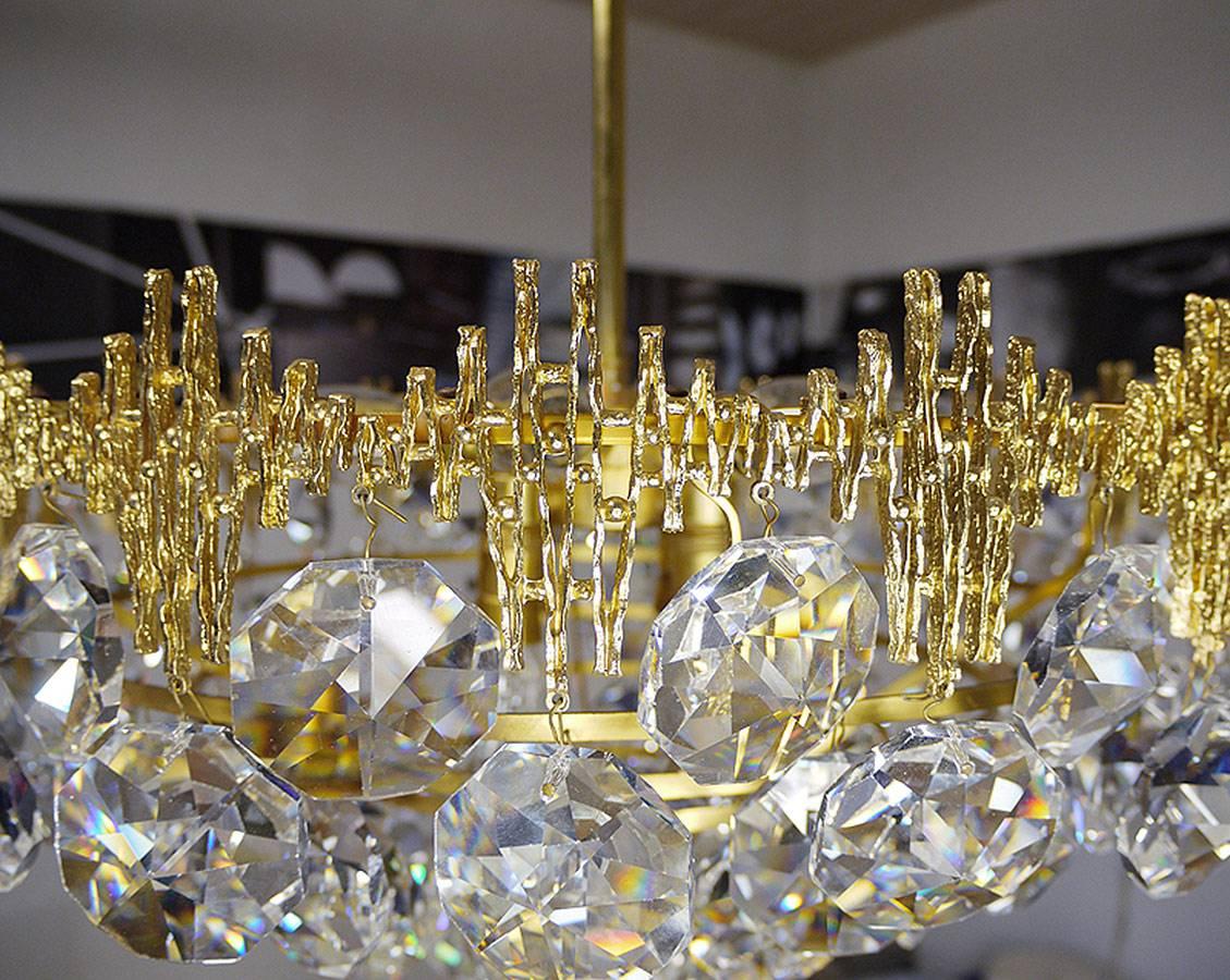 Large chandelier with faceted crystal pendants on a gilt brass frame.
Made by Palwa, Germany in the 1960s.
The lamp takes one large and eight small Edison base bulbs.
 