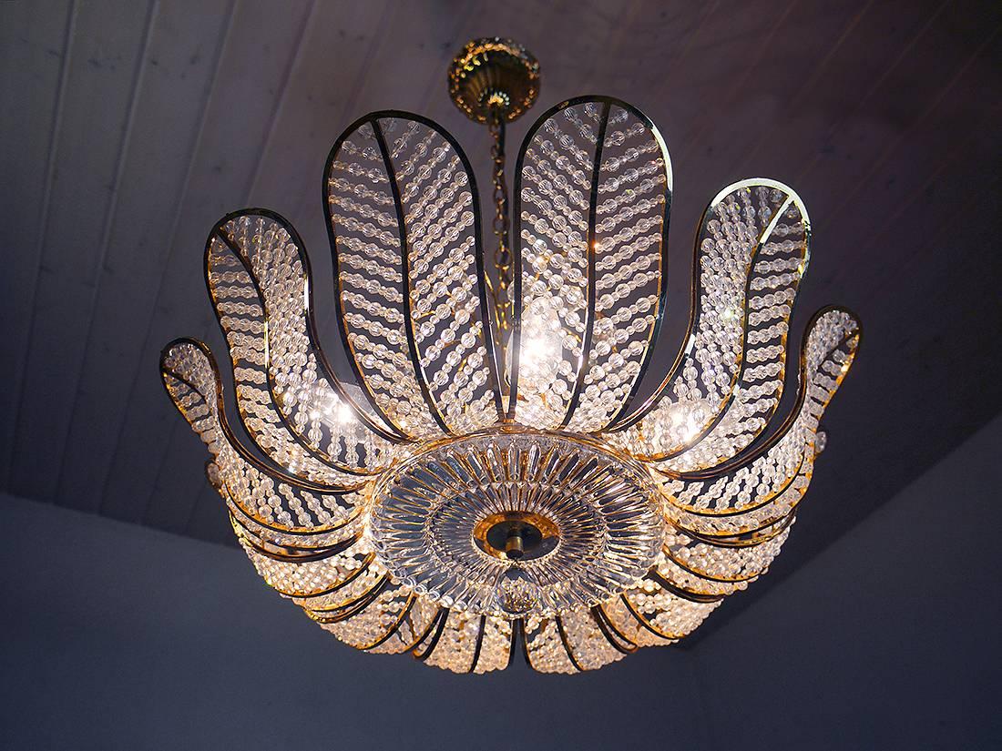 Luxuriöser vergoldeter Kronleuchter mit Swarovski-Kristallen von Kurt Faustig/München, Deutschland.
Die Lampe kann mit sechs kleinen Edison-Birnen betrieben werden.
 