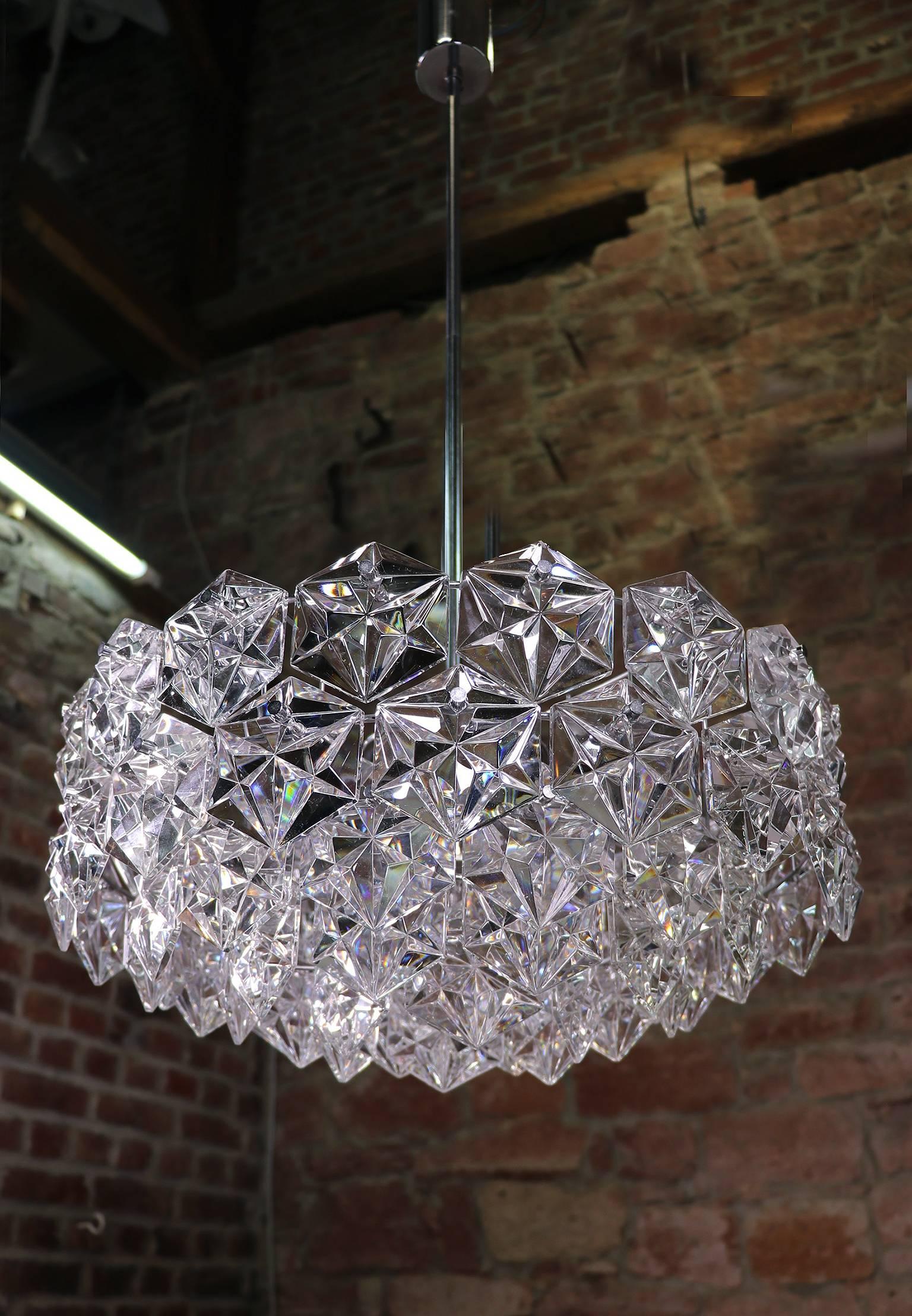 Elégant grand lustre à cinq niveaux avec des cristaux sur une structure en laiton chromé. Fabriqué par Kinkeldey, Allemagne, dans les années 1960. 

Éclairage : six petites ampoules à culot E14 et une grande ampoule à vis Edison à culot E27.